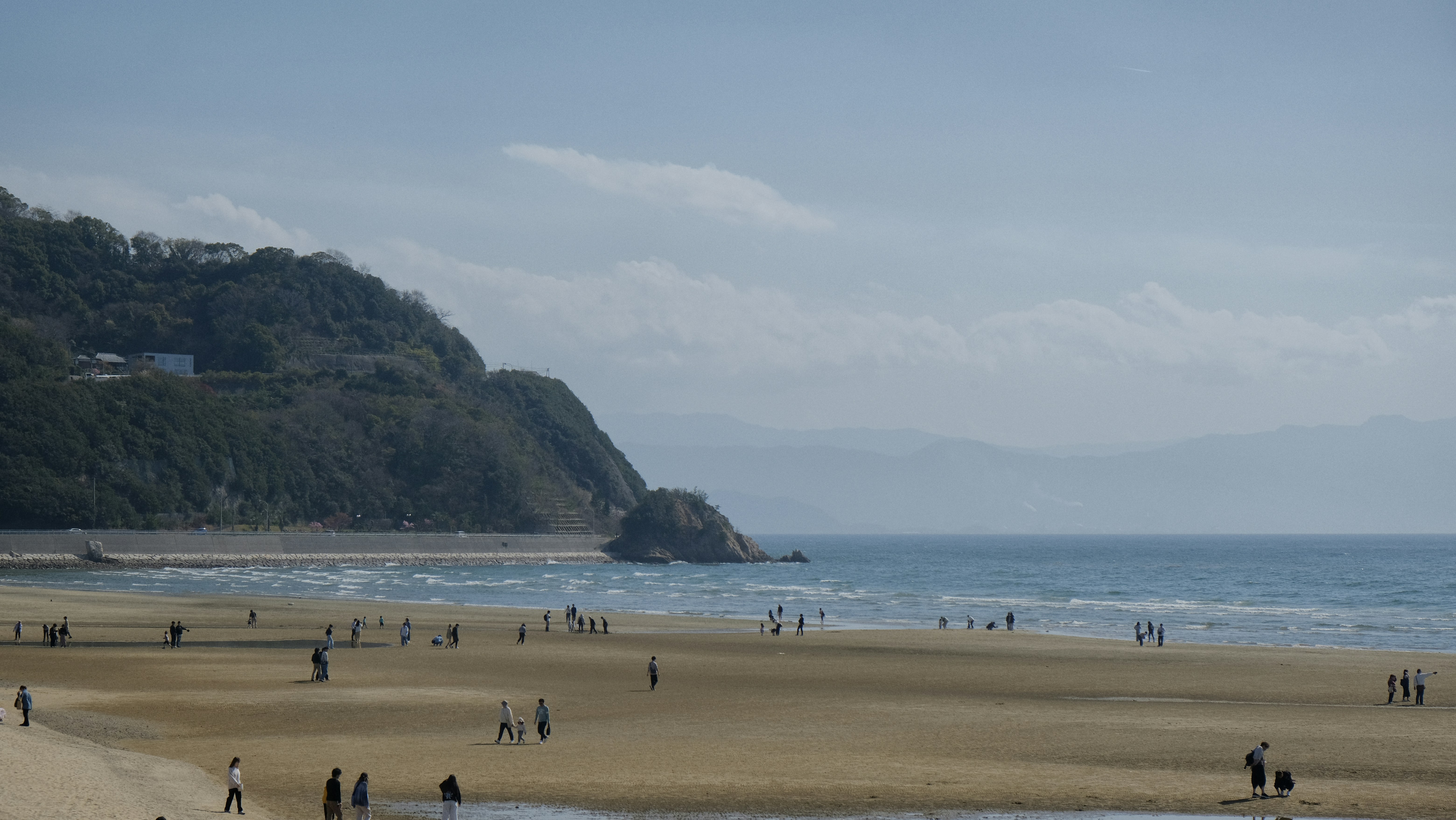 People are enjoying a beautiful beach on a sunny day.