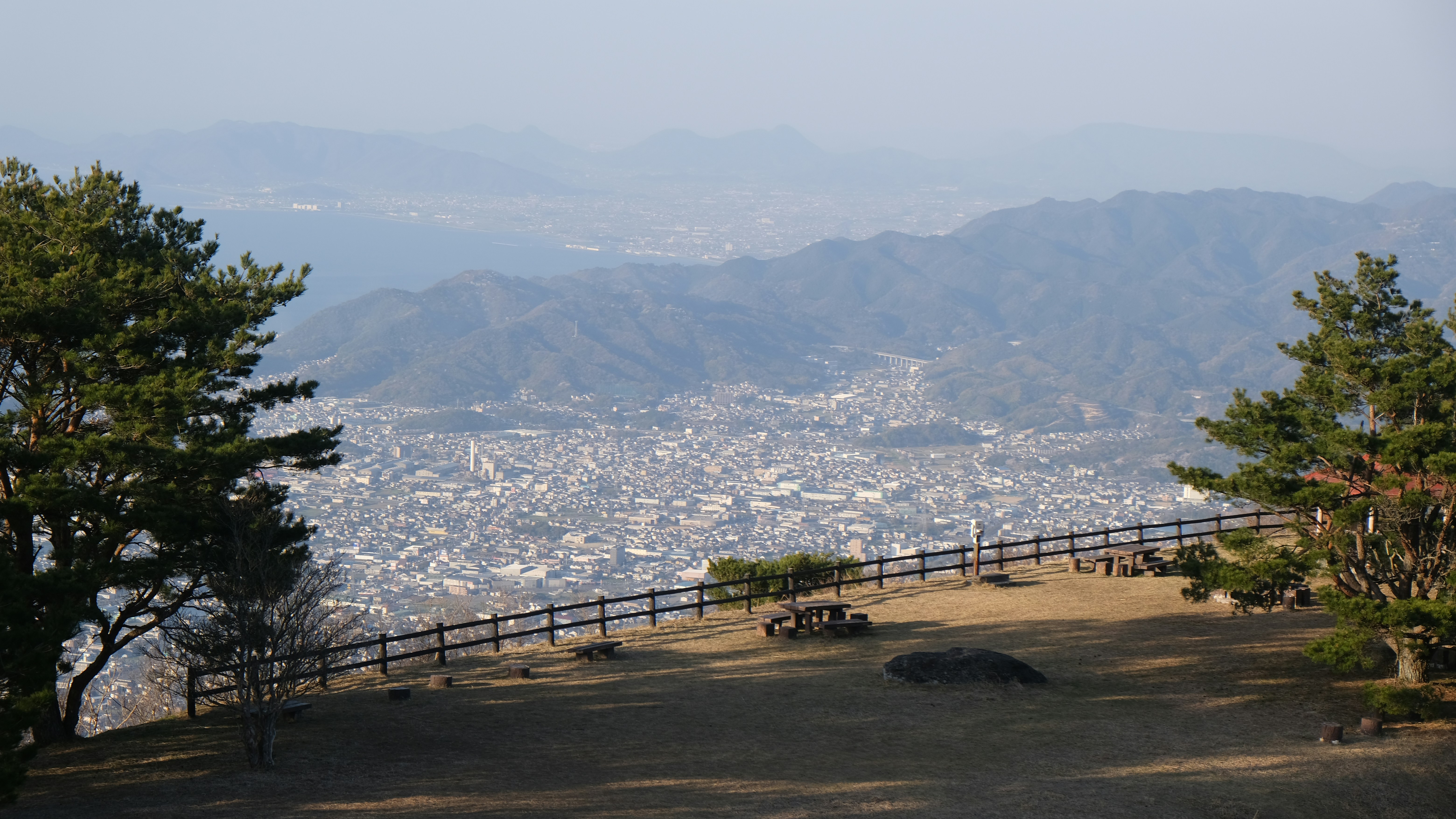 City view from a hilltop with trees.