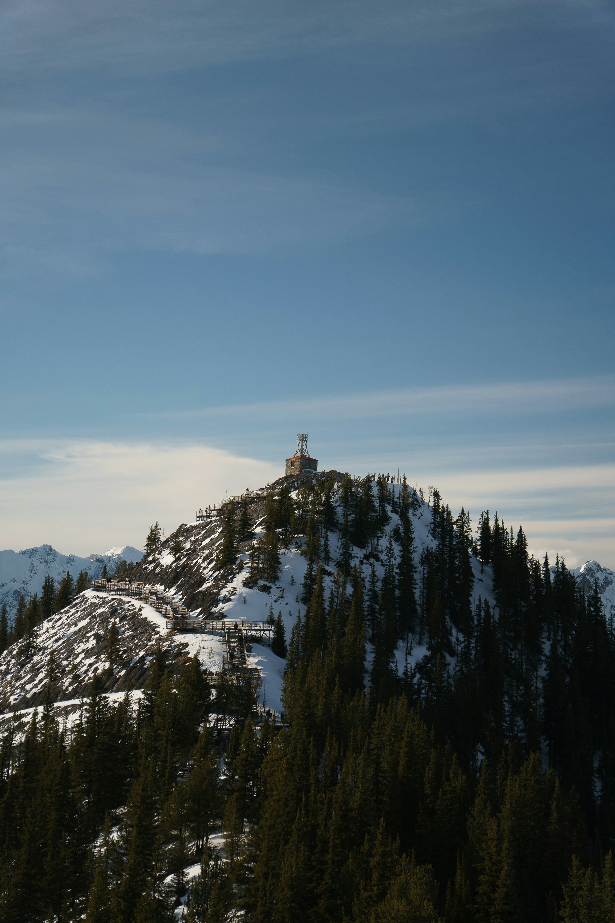 A snowy mountain peak stands against a blue sky.