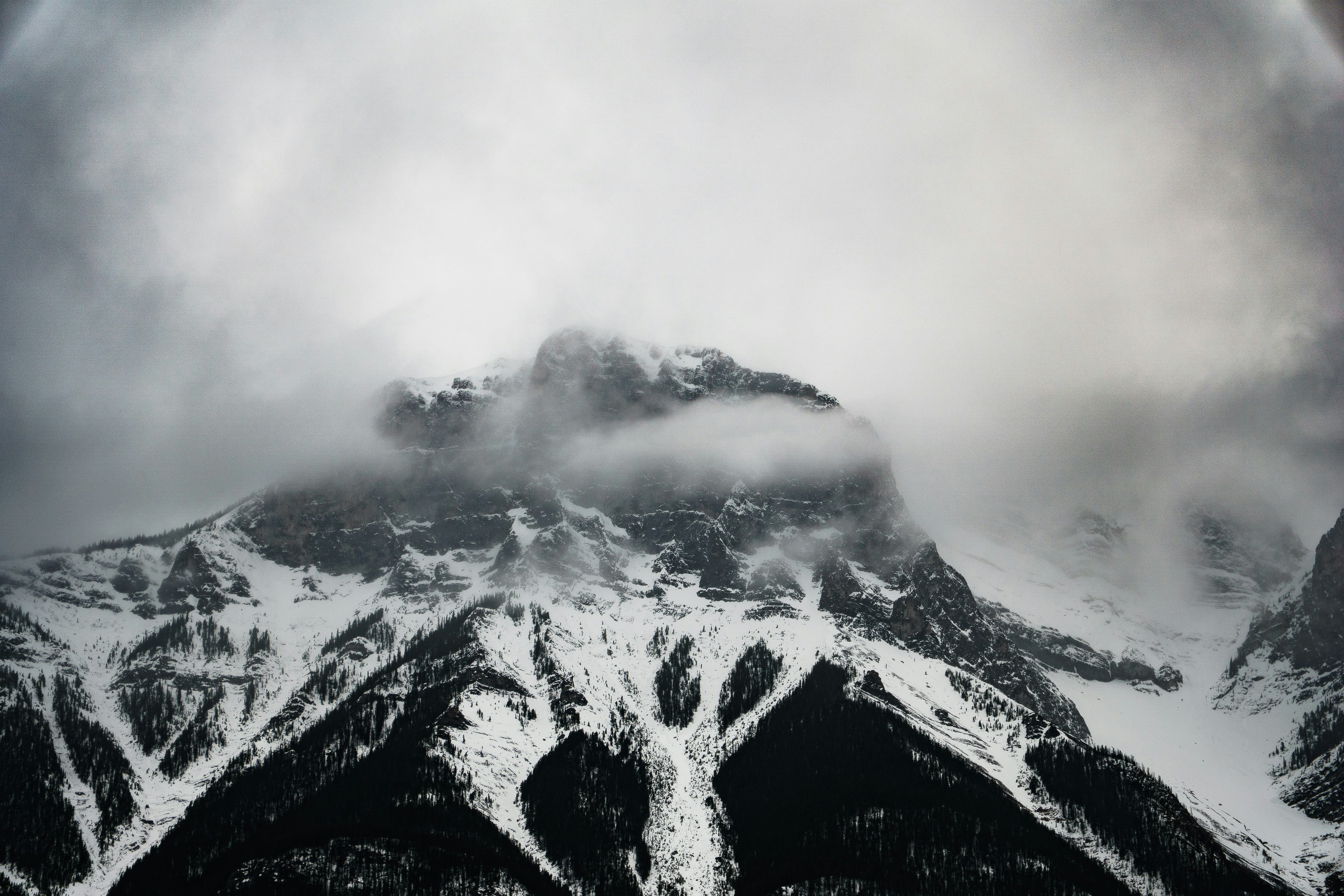 Snowy mountains shrouded in thick, gloomy clouds.