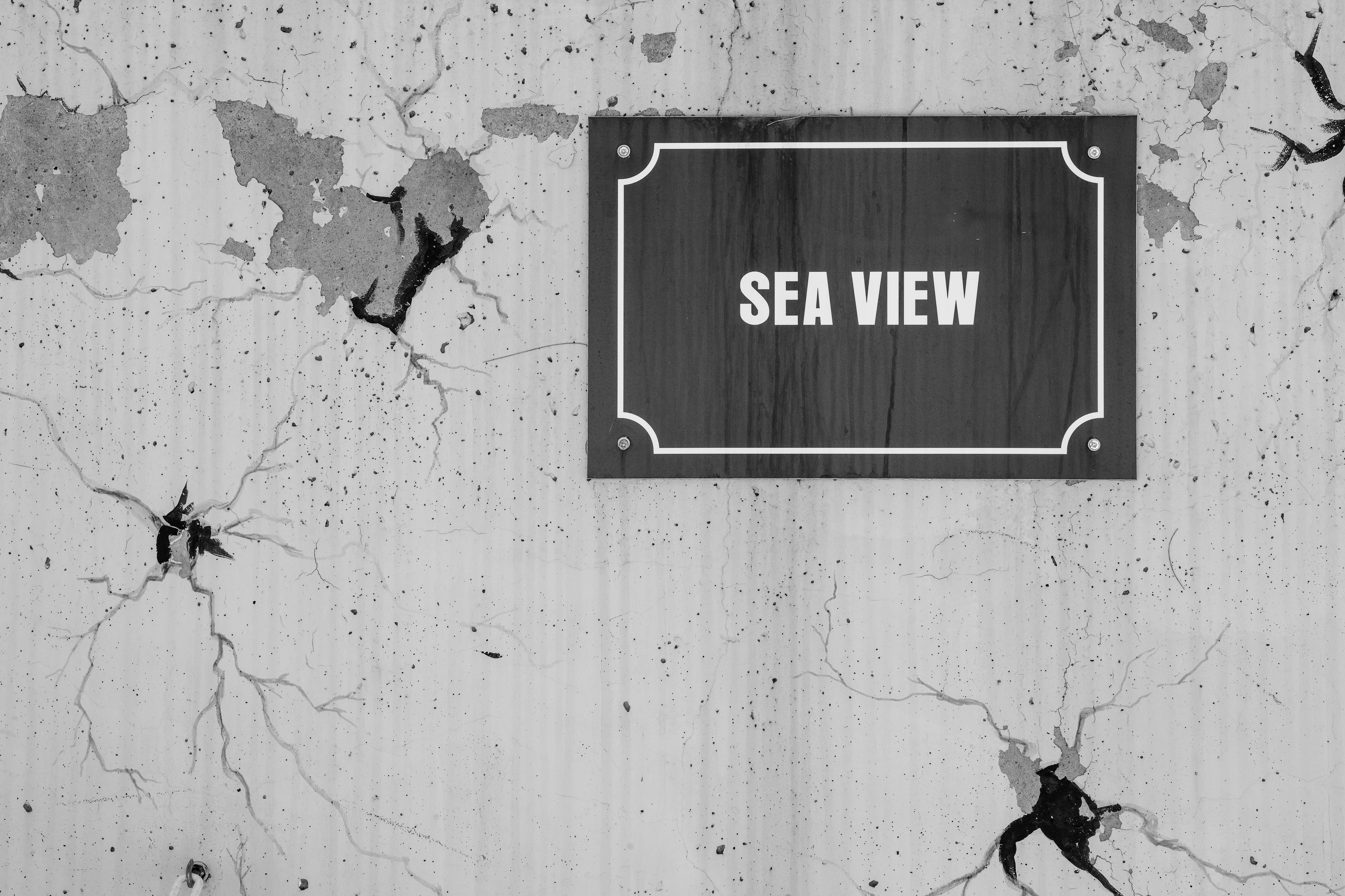 "sea view" sign hangs on a cracked wall.