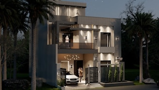 A modern, two-story home is lit at night.
