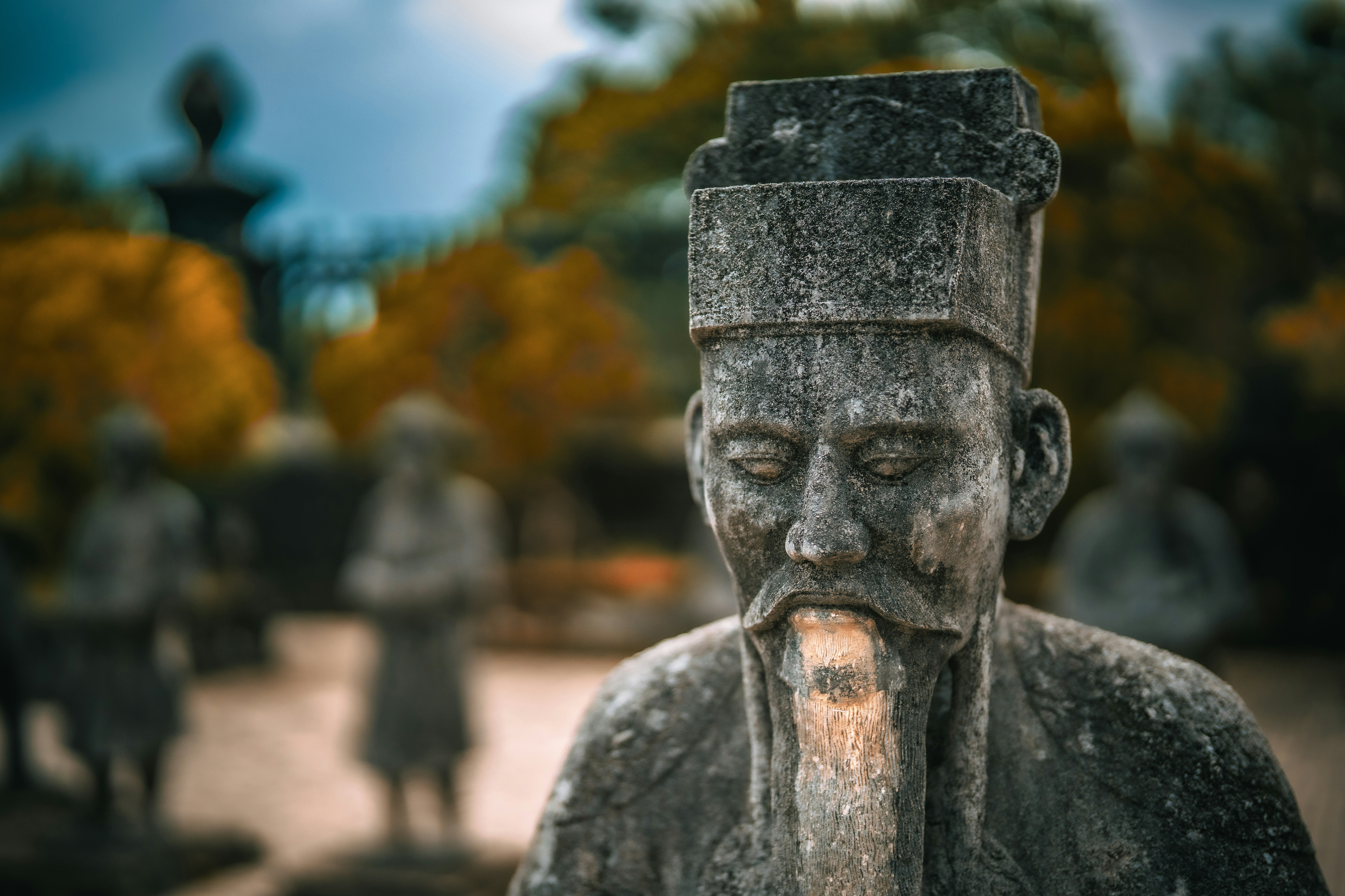 A stone statue of an asian man.