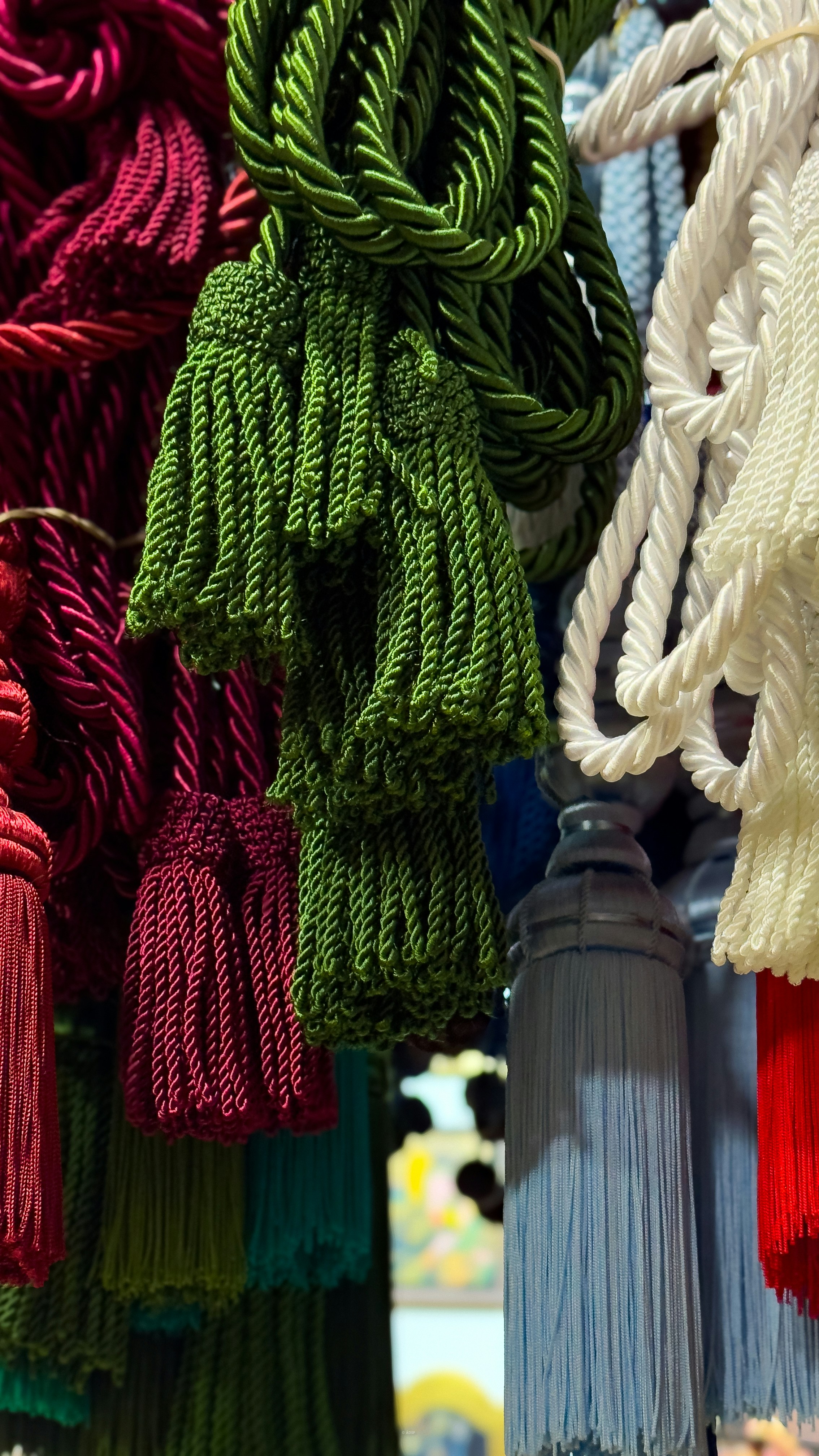 Borlas artesanales colgadas en una tienda tradicional de Andalucía. Texturas intensas, colores vibrantes y detalles que hablan de cultura y oficio./ Handmade tassels hanging in a traditional Andalusian shop. Rich textures, vibrant colors, and the soul of Spanish craftsmanship. Original photo taken in Marchena, Andalusia (Spain) by Ángel D. Sarria Fotografía original tomada en Marchena, Andalucía, por Ángel D. Sarria