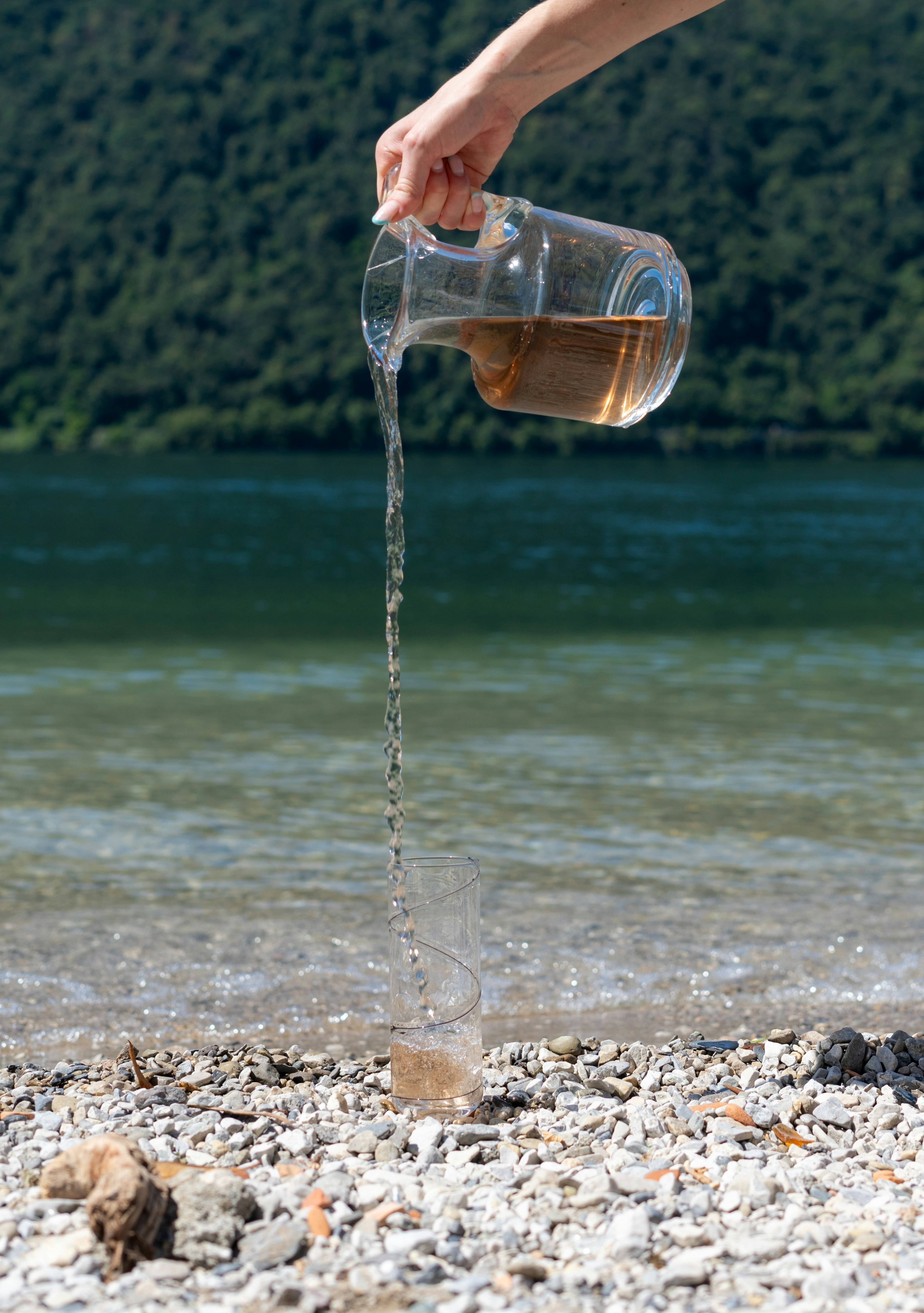 Water is poured from a jug onto the beach.