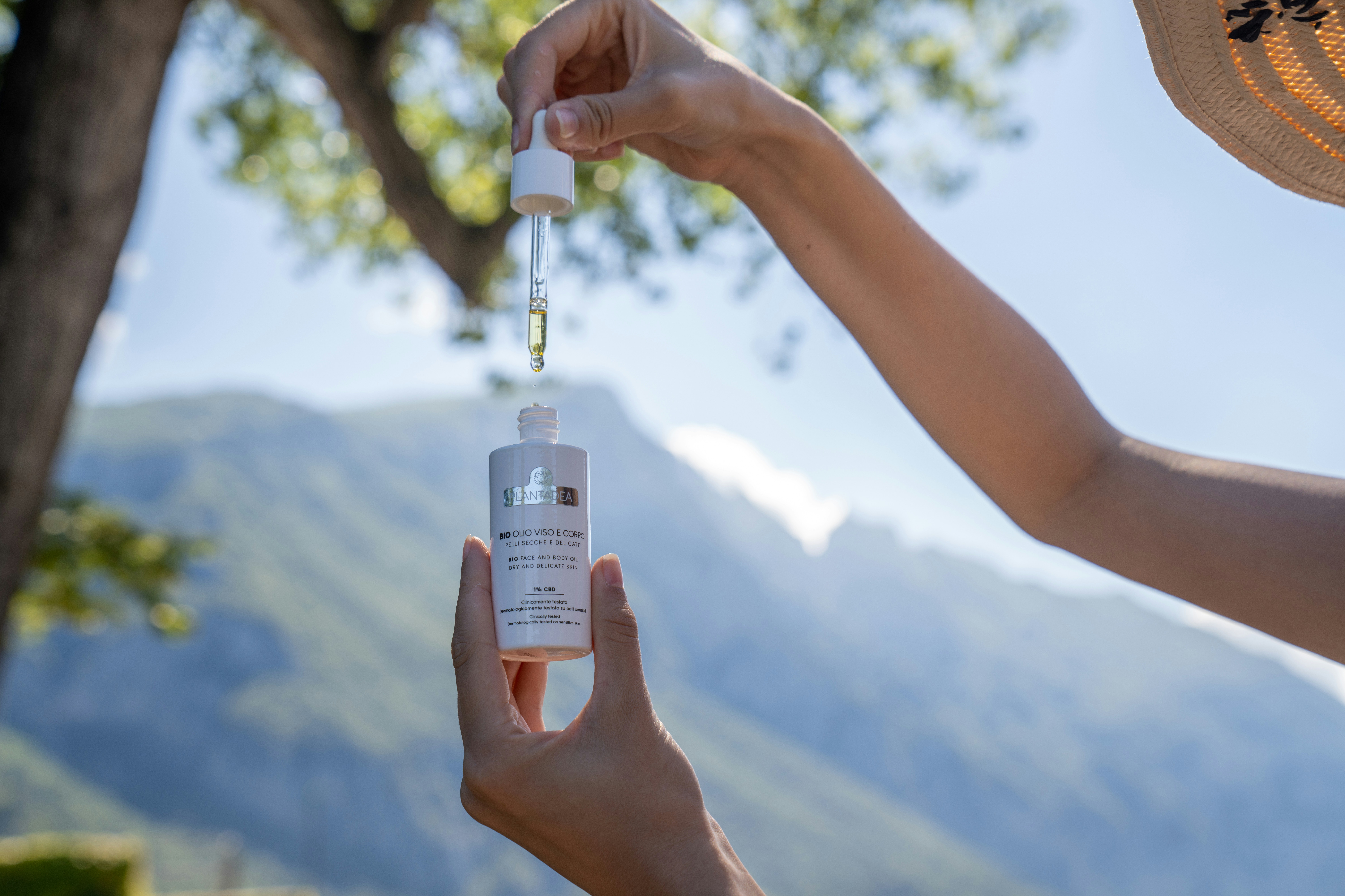 Woman holds a skincare bottle with serum.