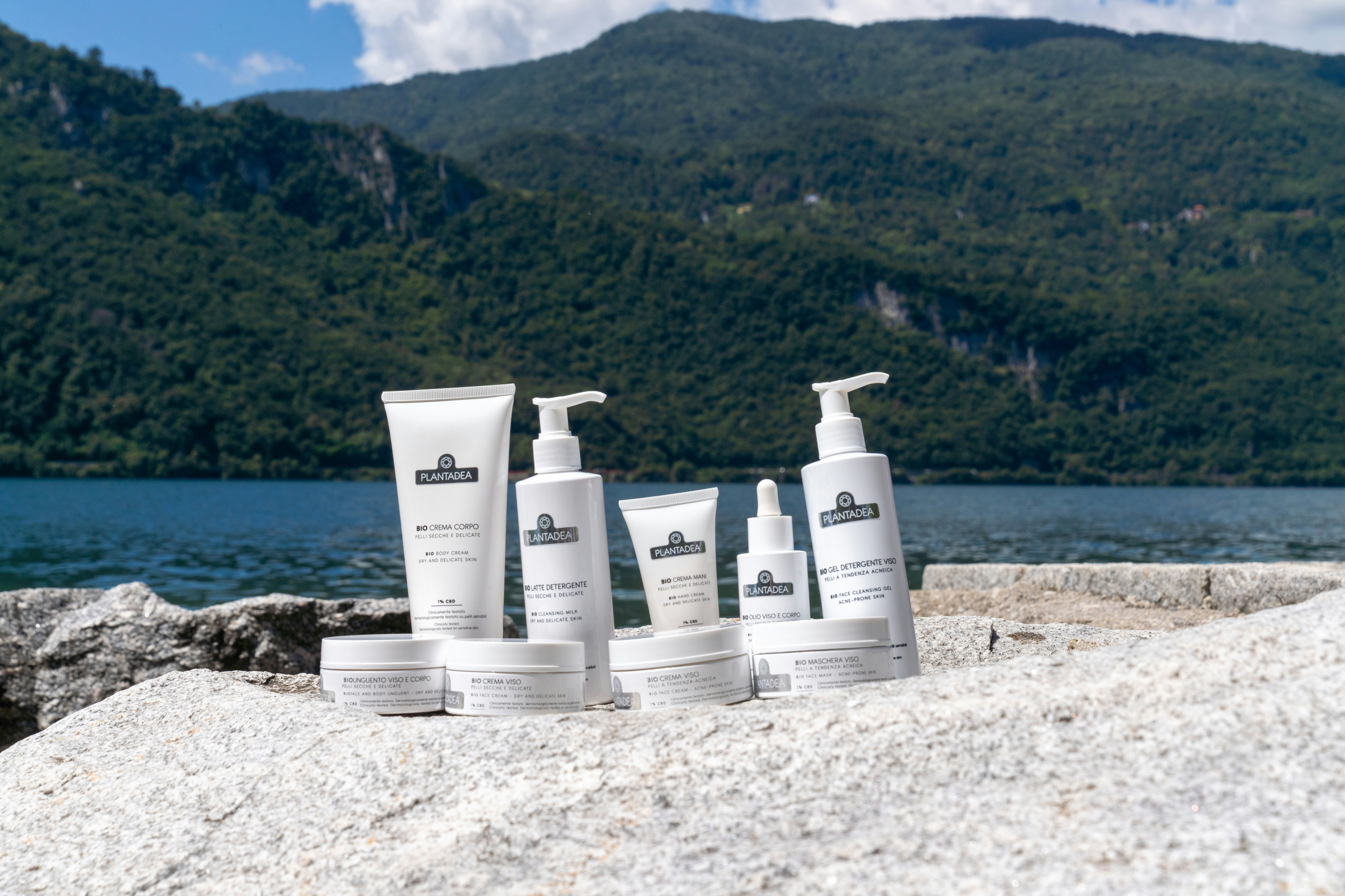 Skincare products displayed with a mountain and lake background.