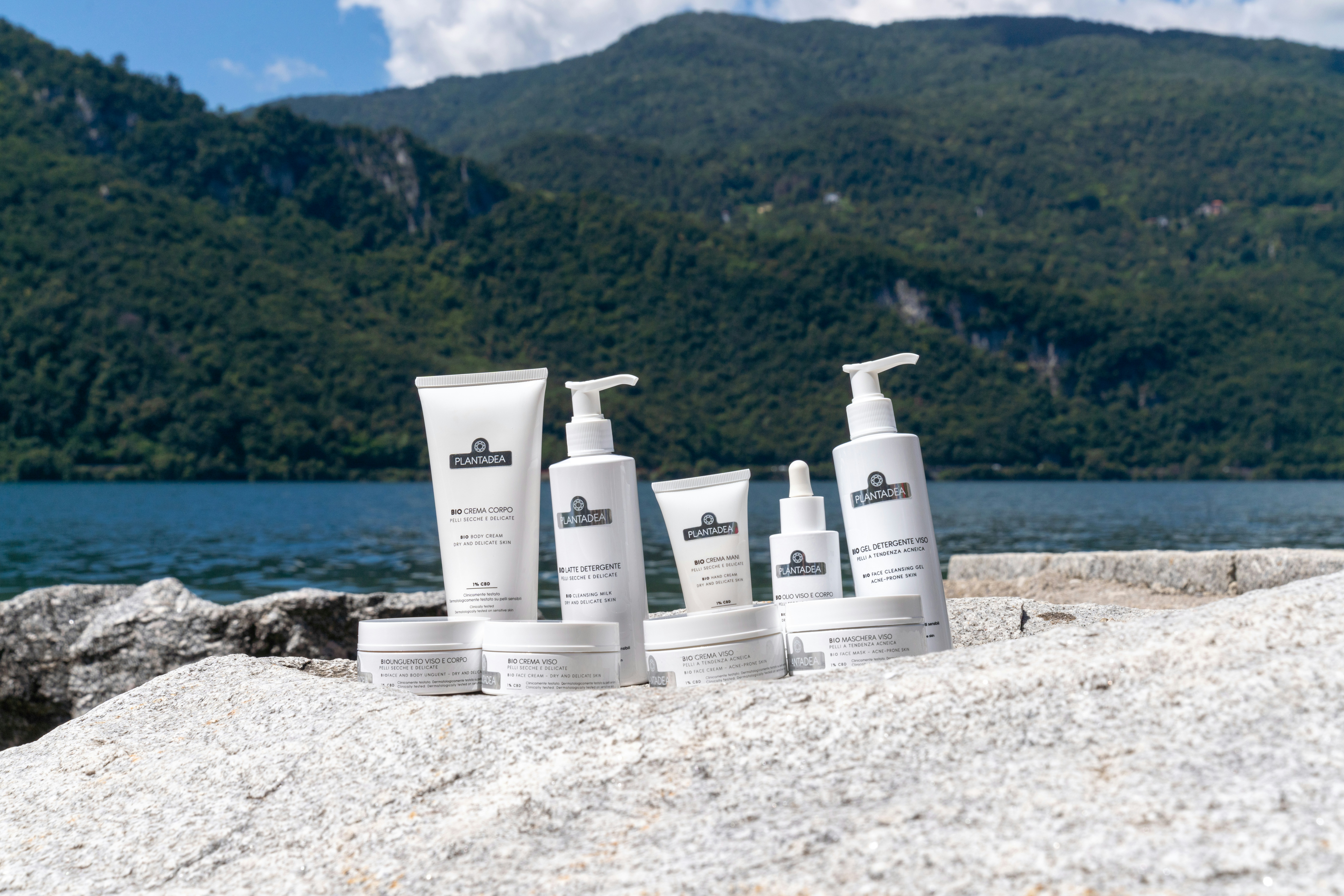 Cosmetics products are set outdoors with a landscape background.