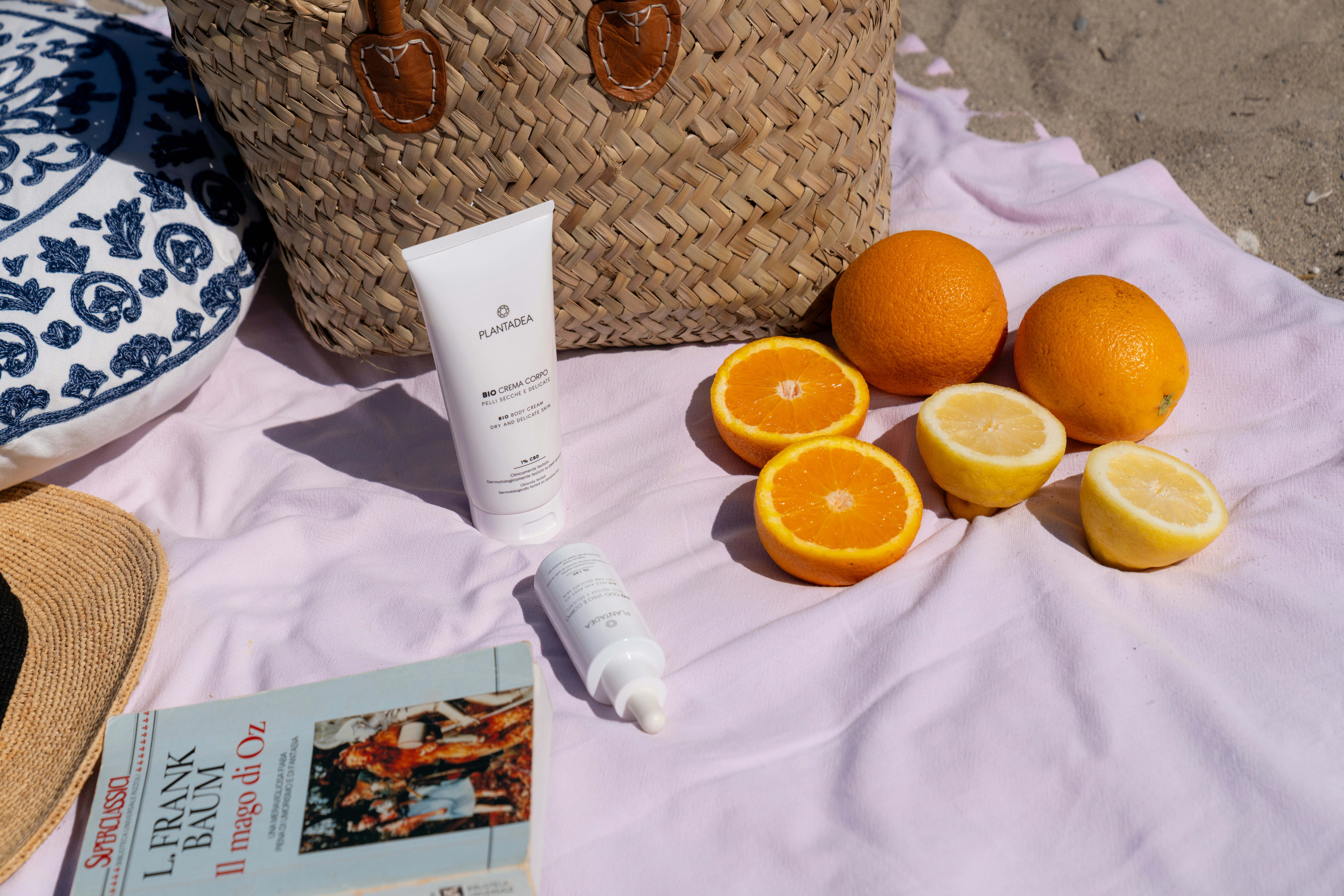 Tube of sunscreen with SPF 50 on a bed of sand next to seashells.