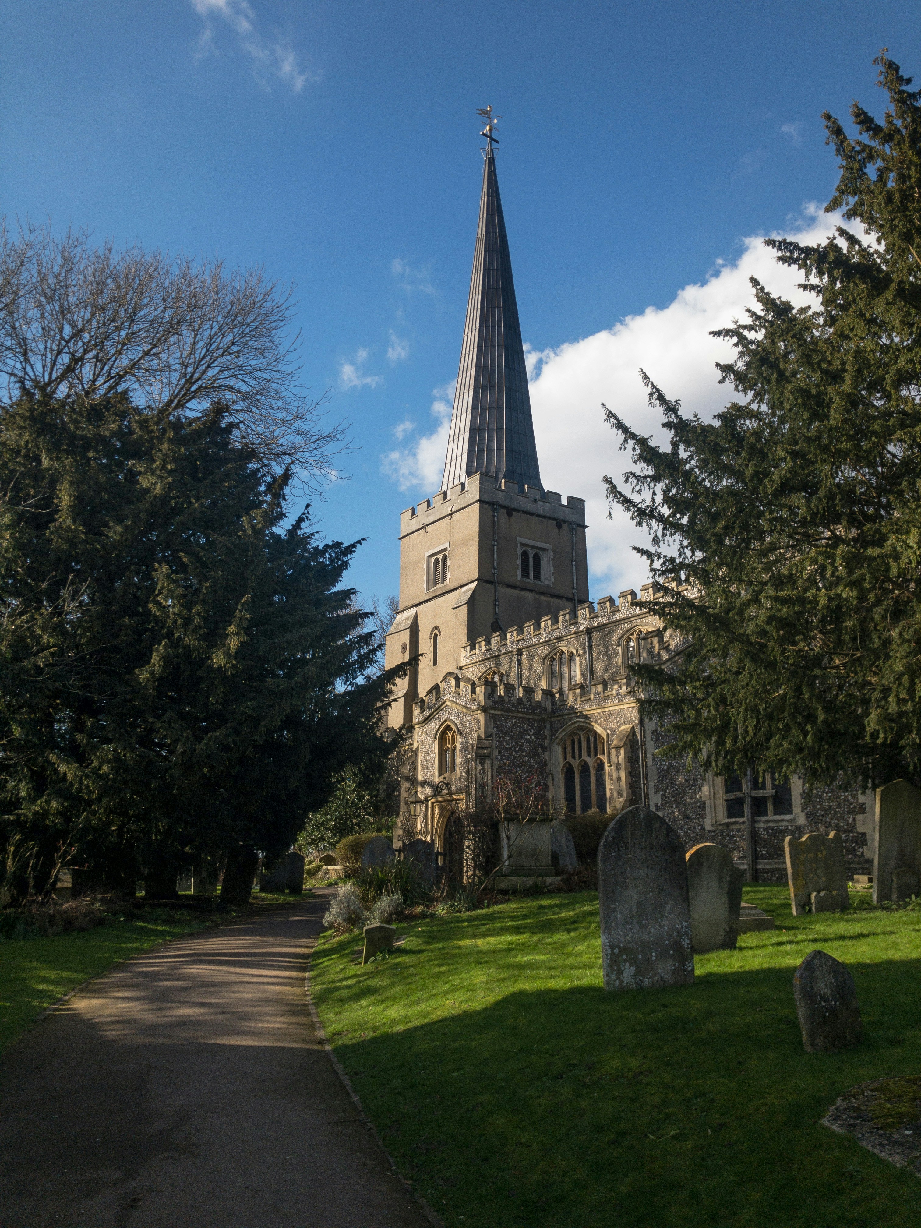 A church with a tall spire is seen.