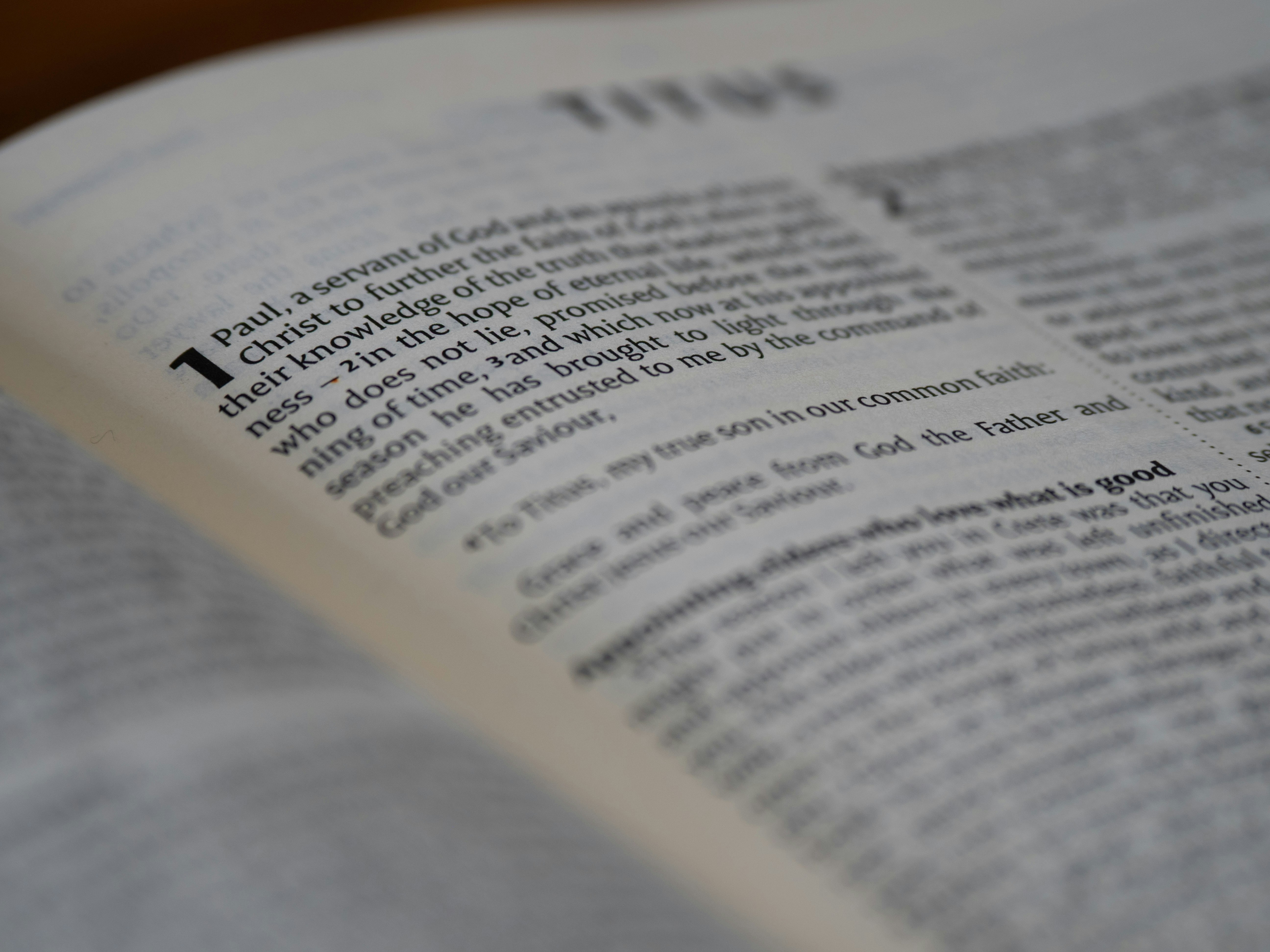 An open bible displays the book of titus.