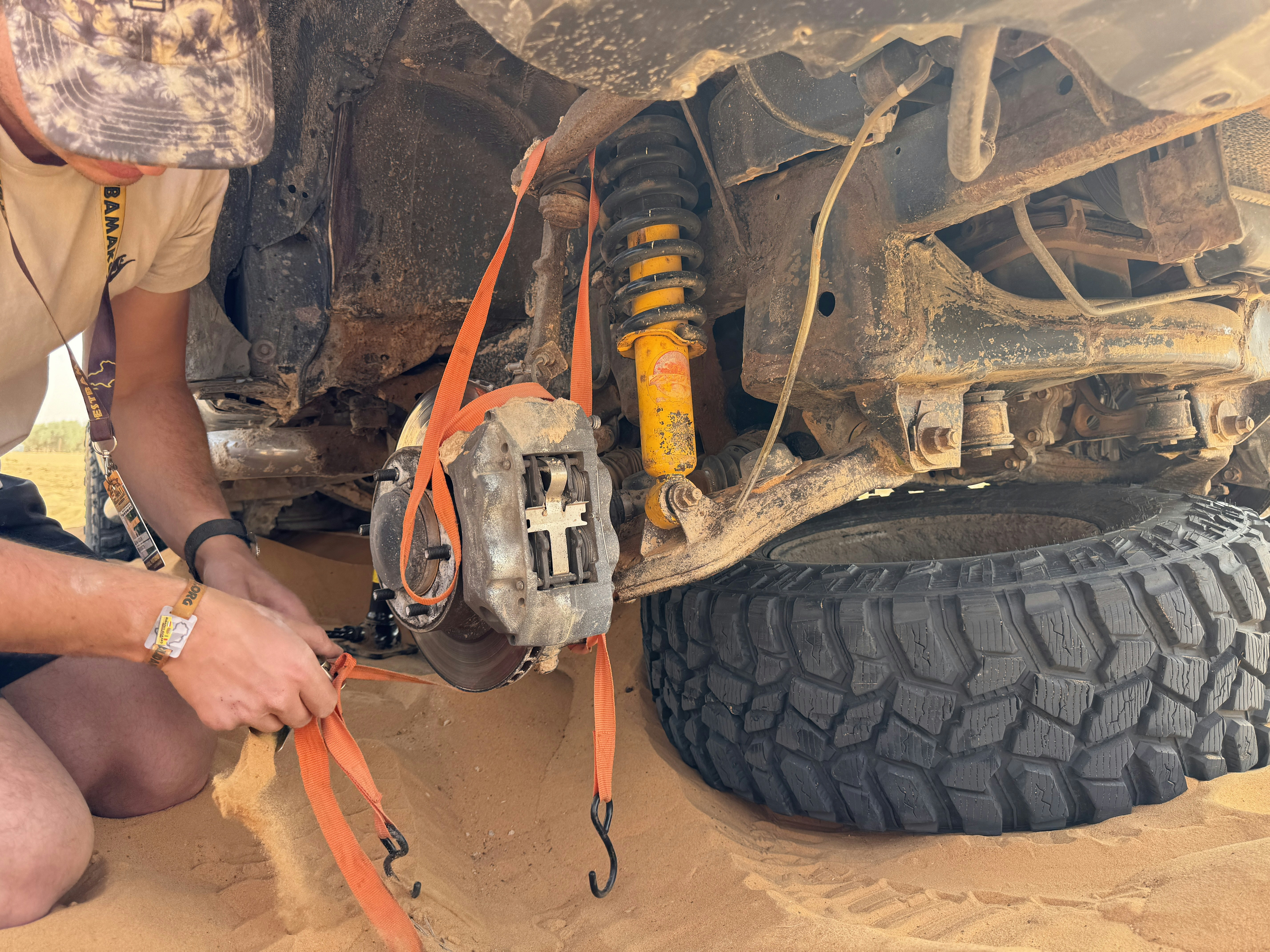 Mechanic performing a pre-purchase inspection on a used car on a lift.