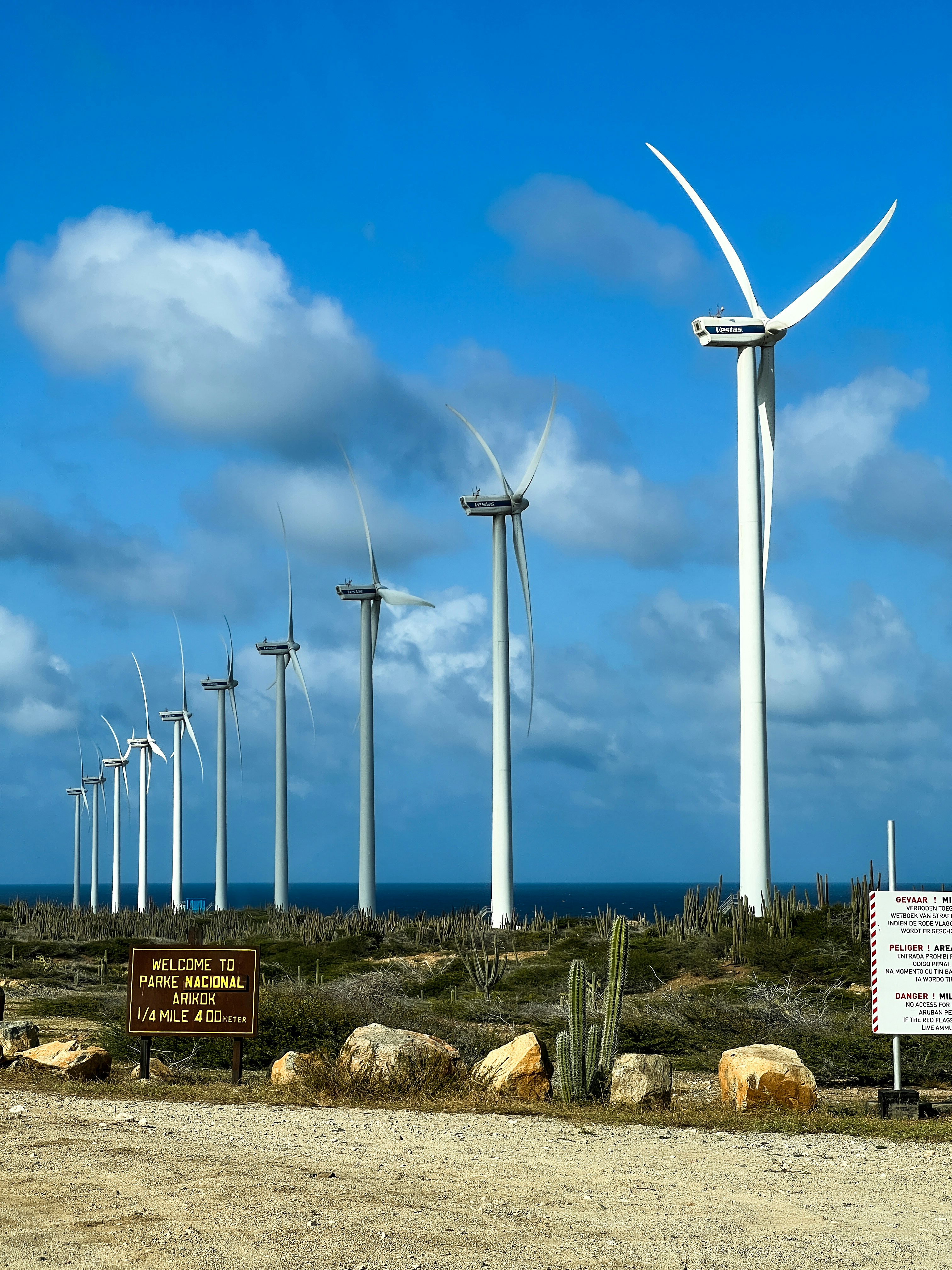 Wind turbines stand tall on a beautiful, blue day.
