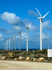 Wind turbines stand tall on a beautiful, blue day.