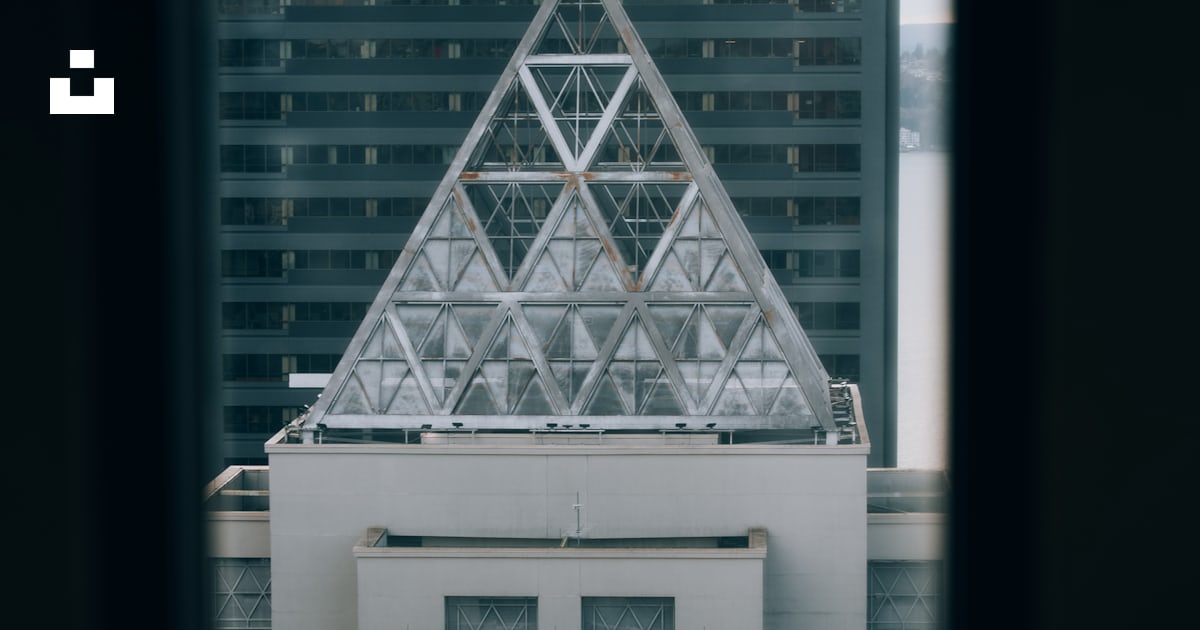 A pyramid-shaped structure atop a city building. photo – Free Building ...