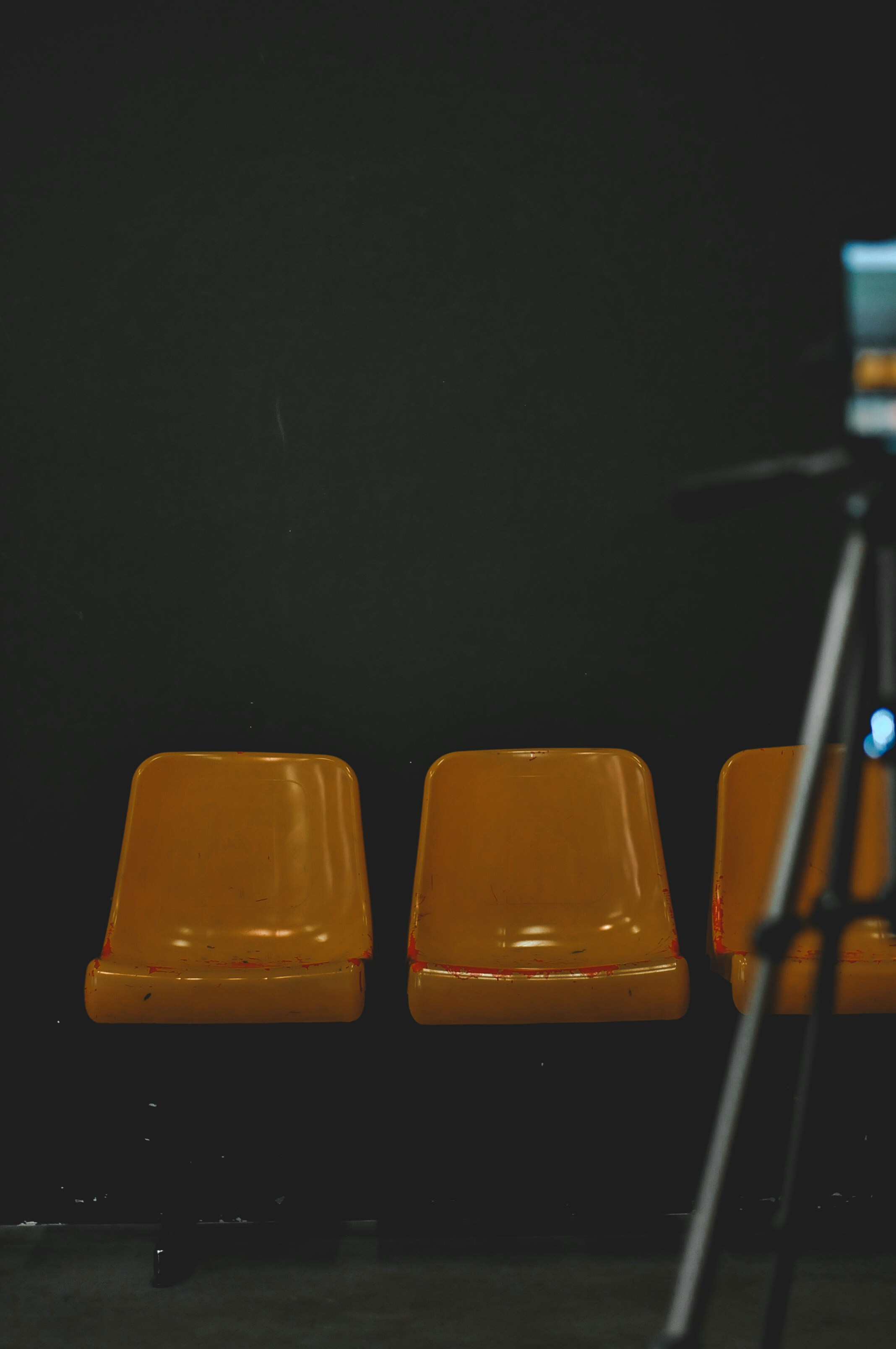 Yellow chairs sit next to a camera on a tripod.
