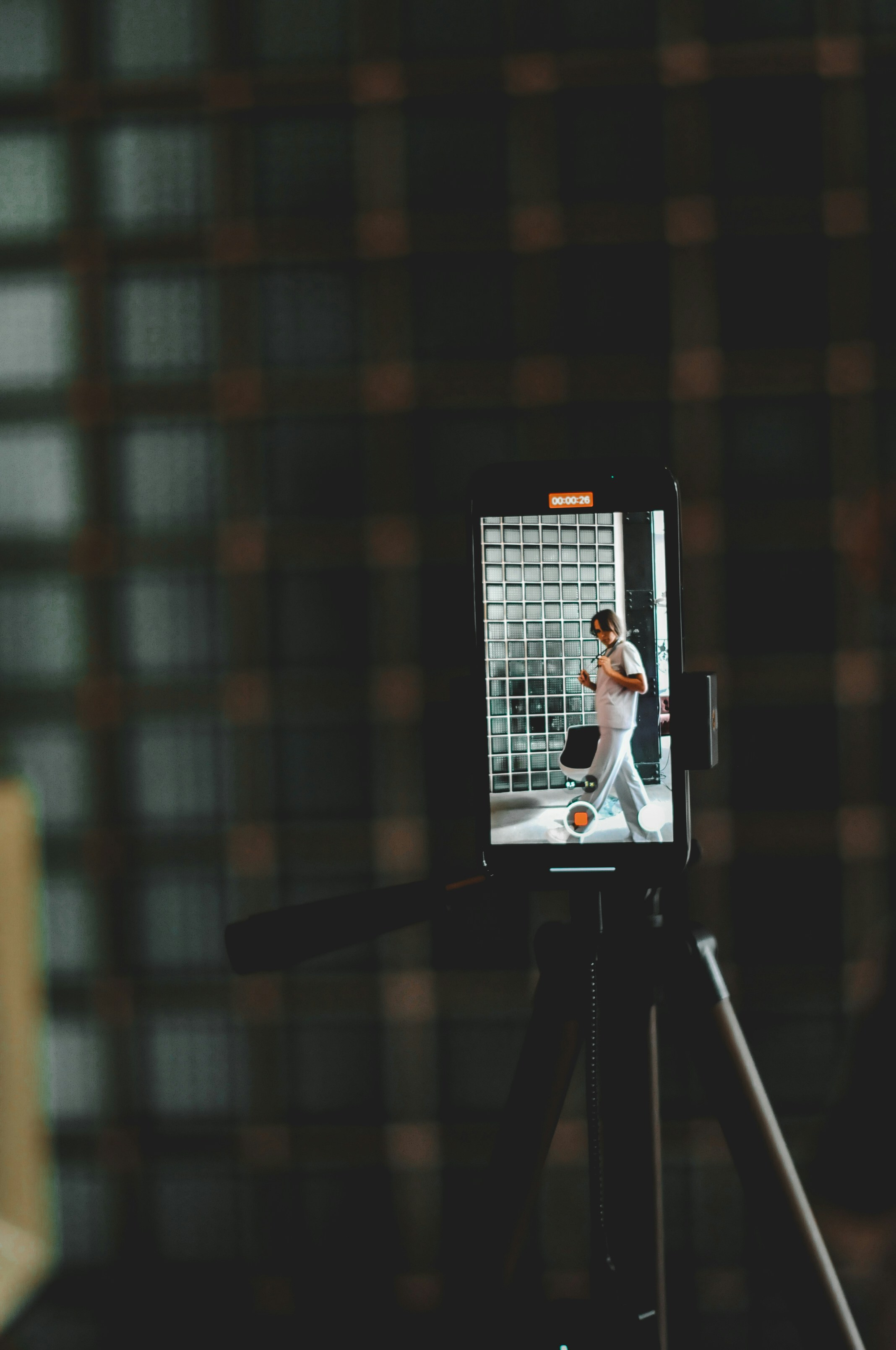 A phone records a person walking through a door.