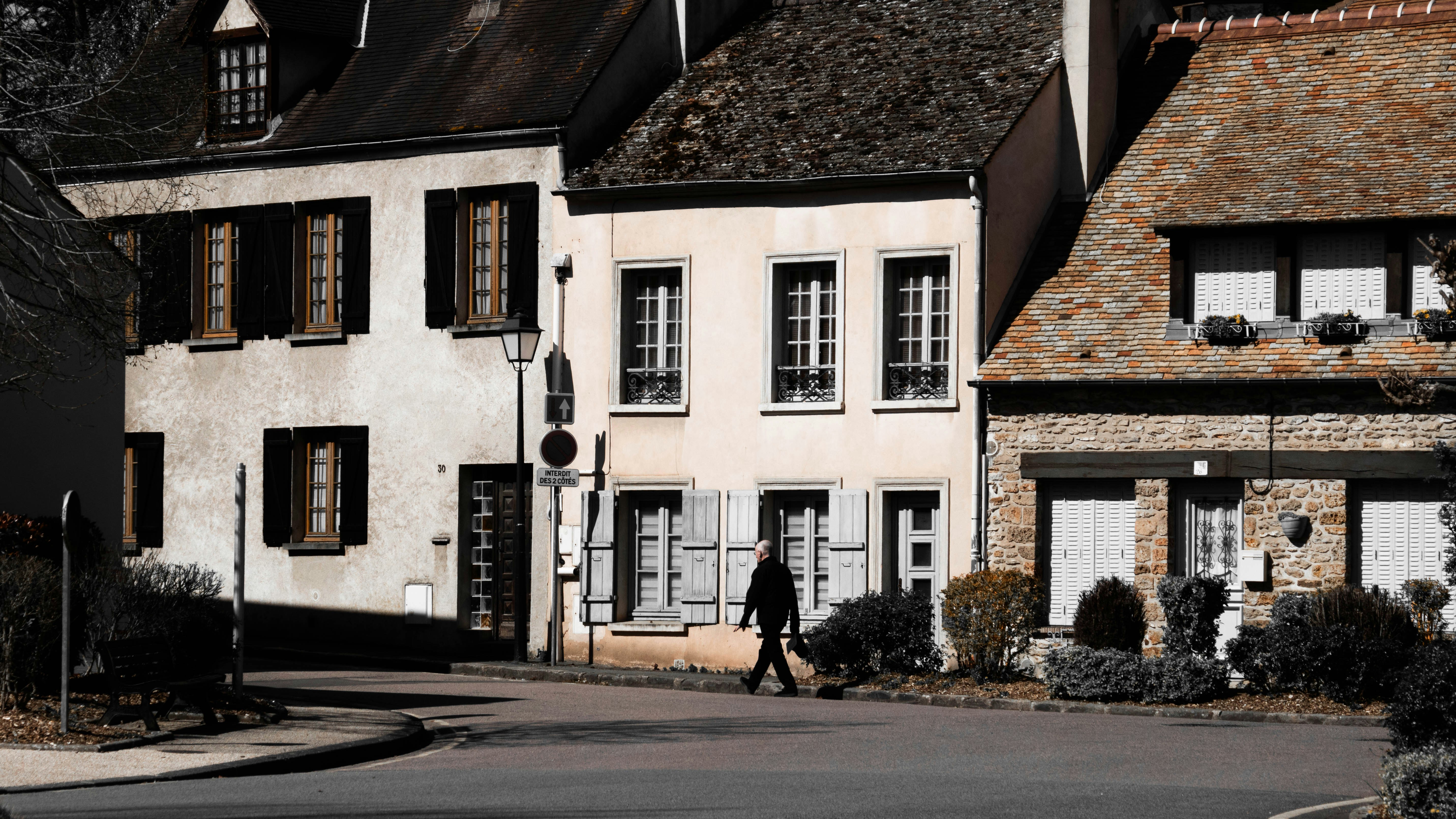 A person walks past charming, old buildings.