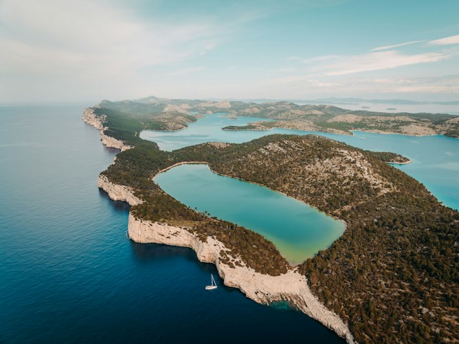 Aerial view of a wooded coastal island and its turquoise bays