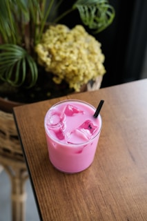 Pink drink with ice and a straw.