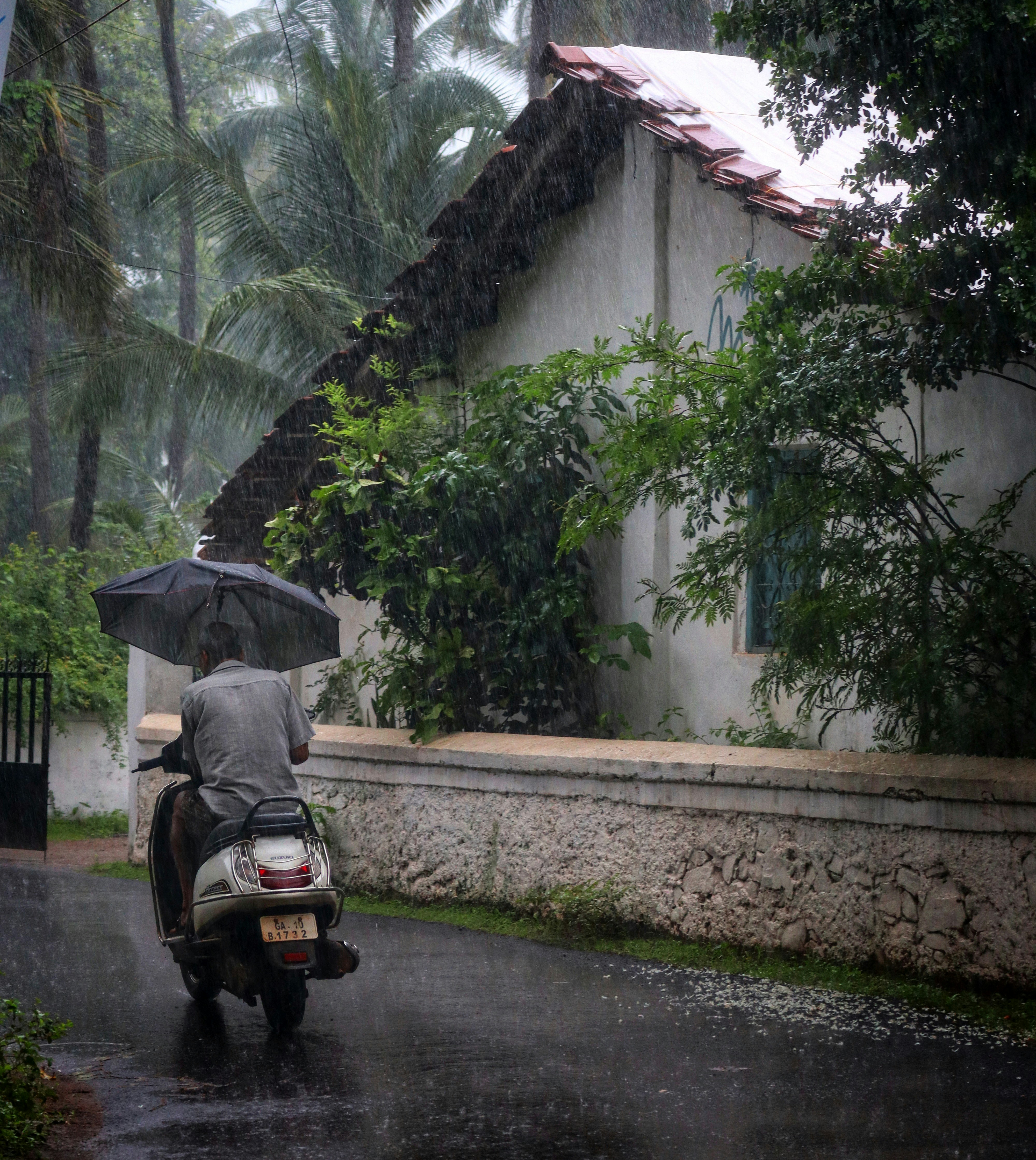 Rider braves the rain on a scooter.