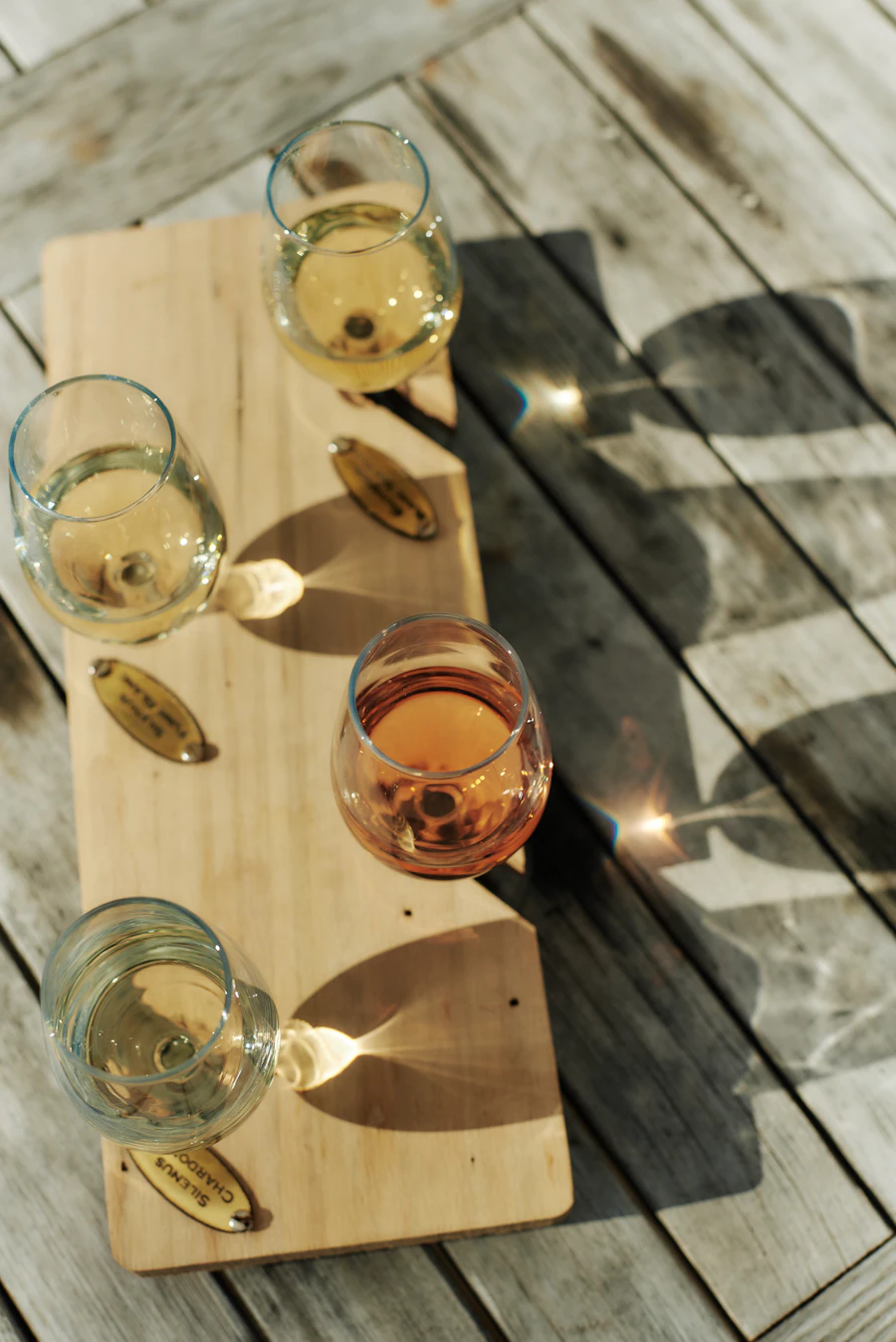 Four glasses of wine on a wooden board