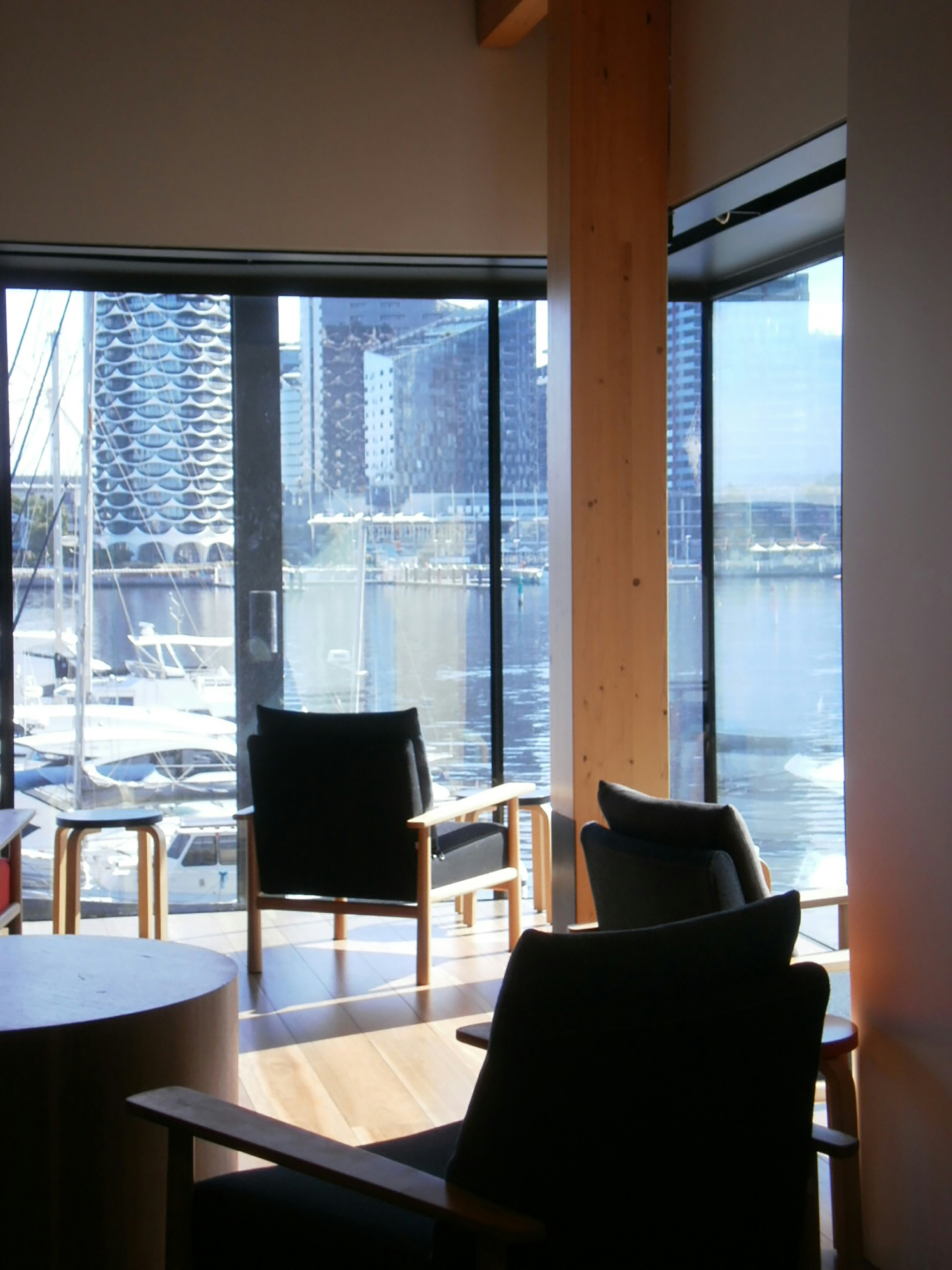 Chairs face harbor views in a bright room.