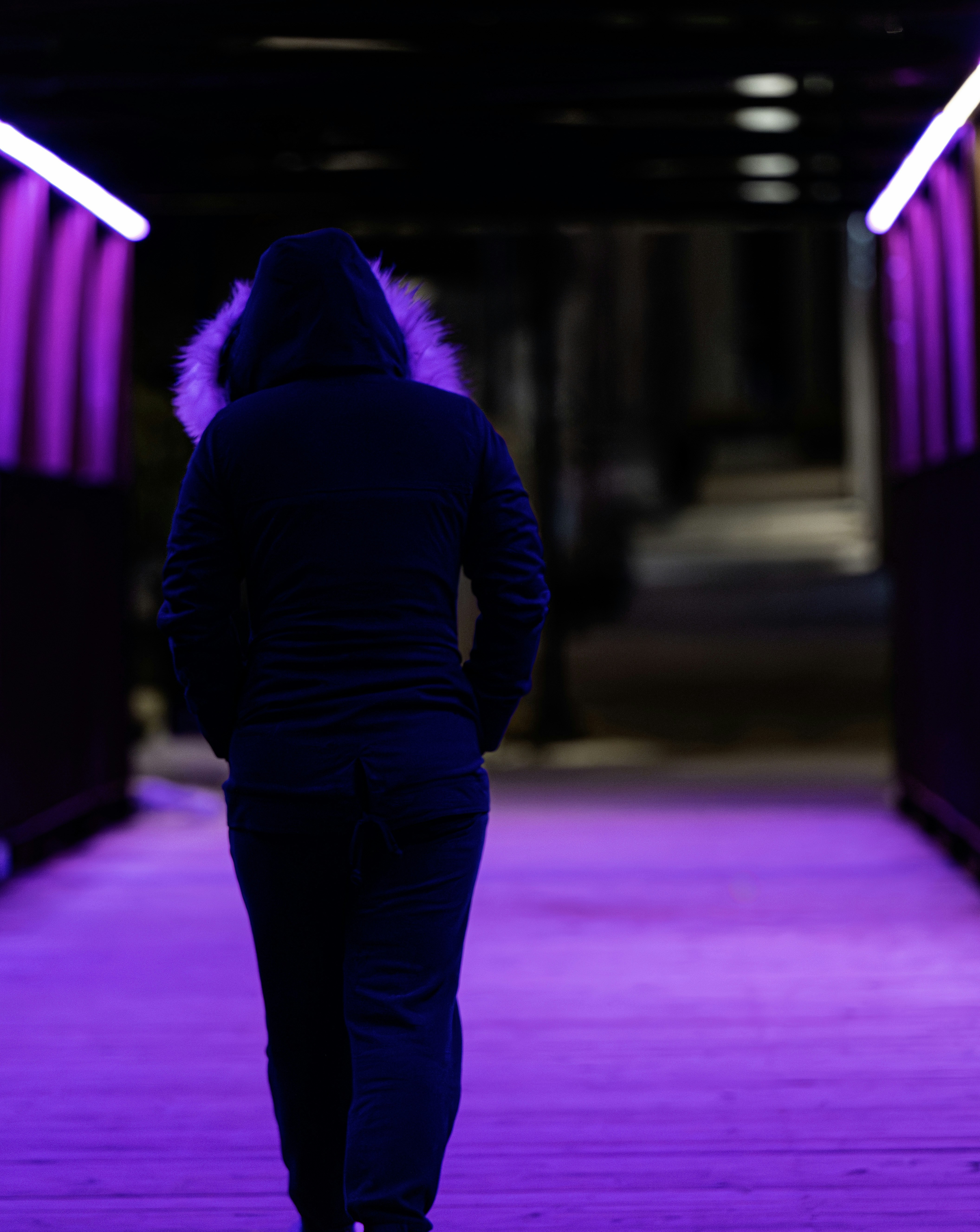A person walks through a lit tunnel.