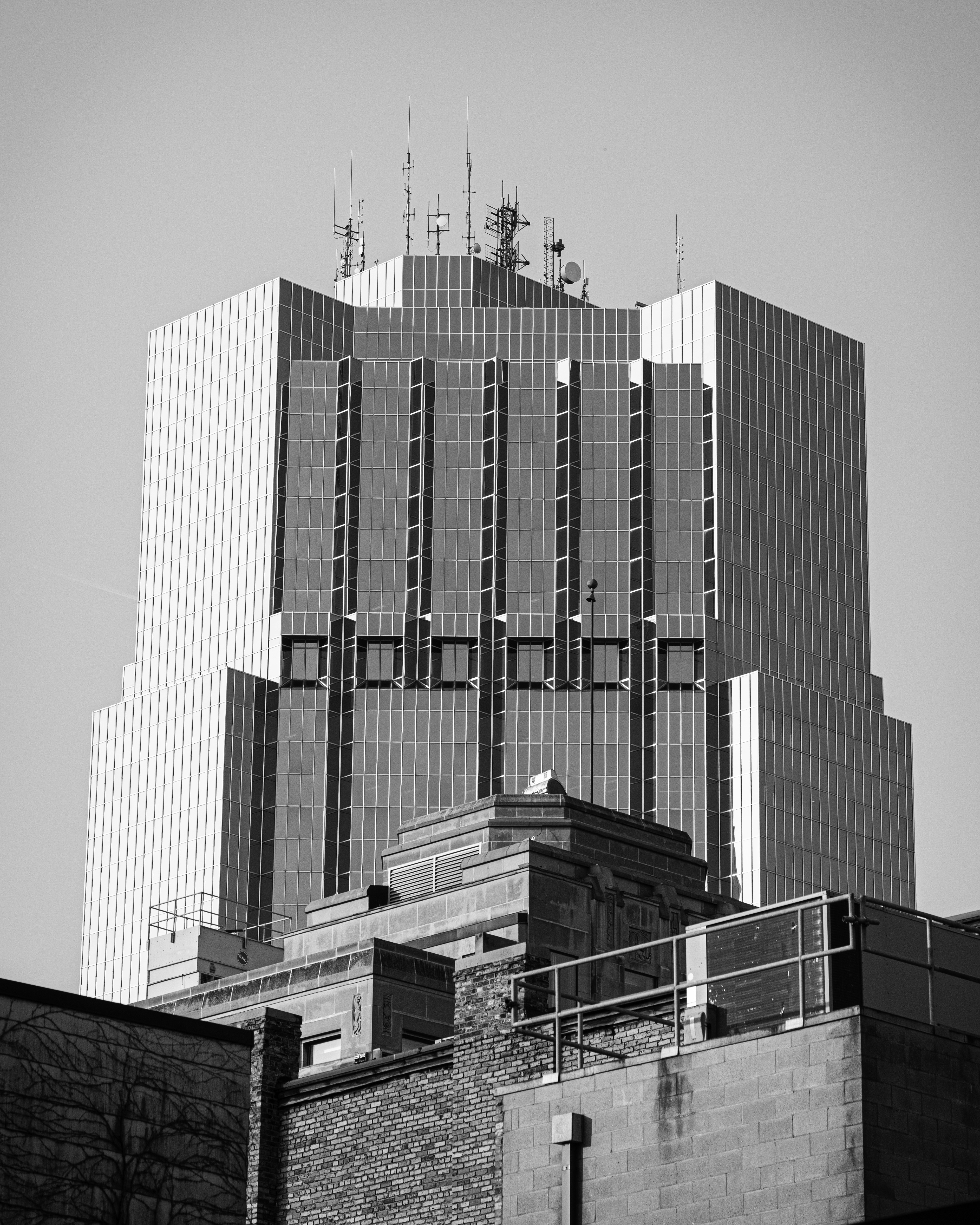 A tall modern building rises above smaller structures.