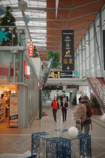 People walk through a modern indoor shopping center.
