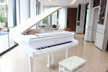 A white grand piano in a luxurious room.