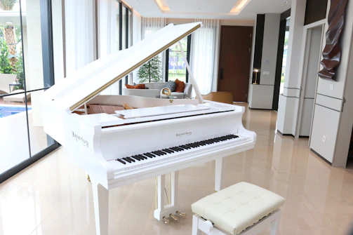 A white grand piano in a luxurious room.
