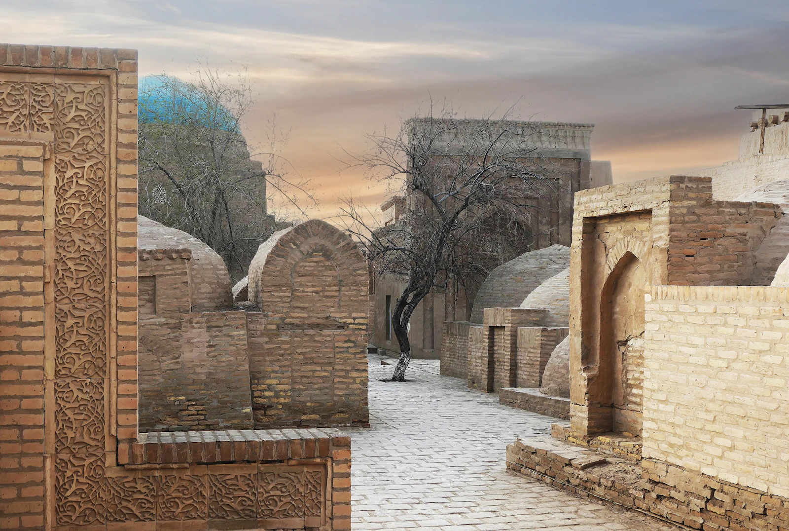 Ancient buildings lining a narrow brick pathway — the heritage behind Silk Route Holding