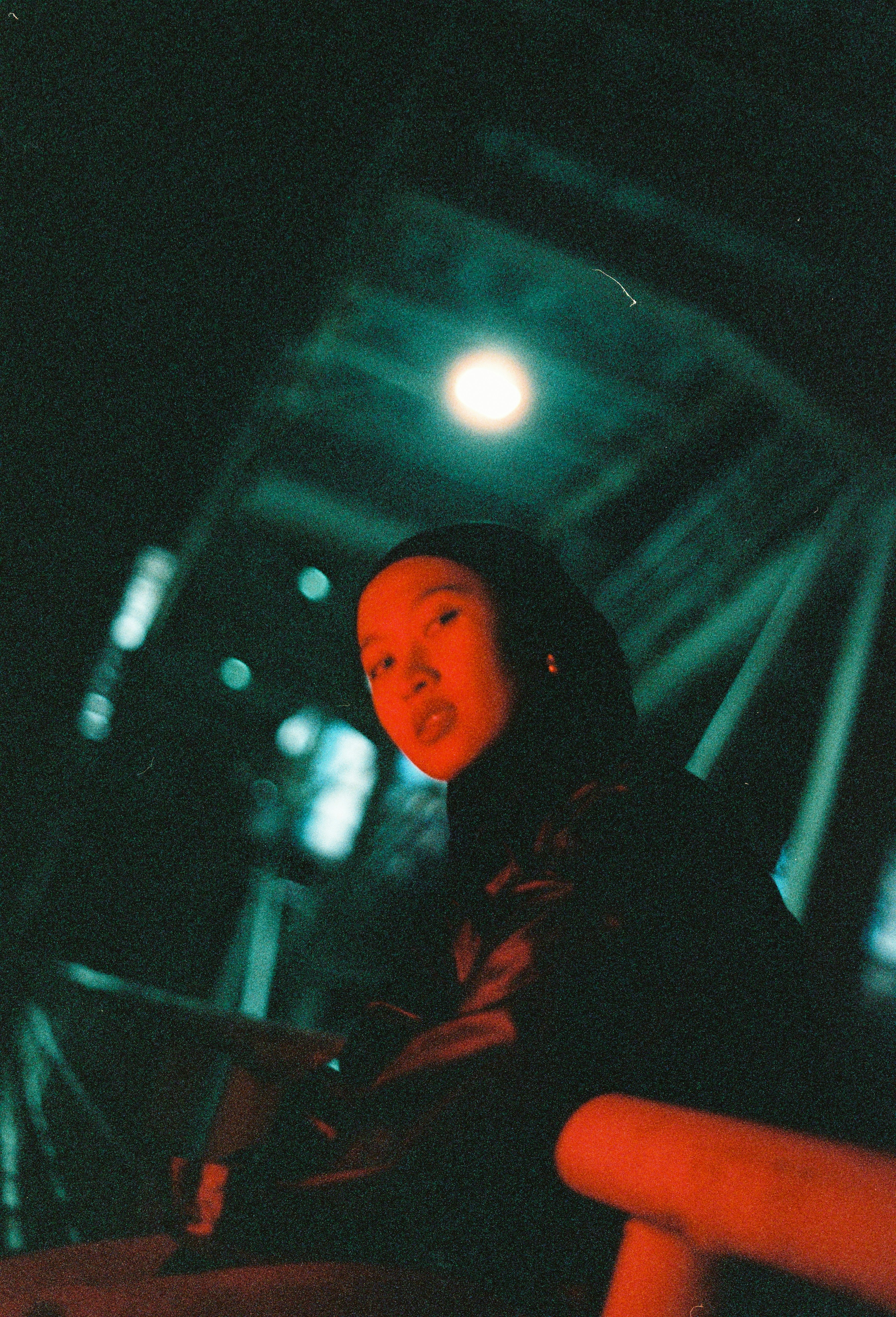 Woman under a bridge looks at the camera.