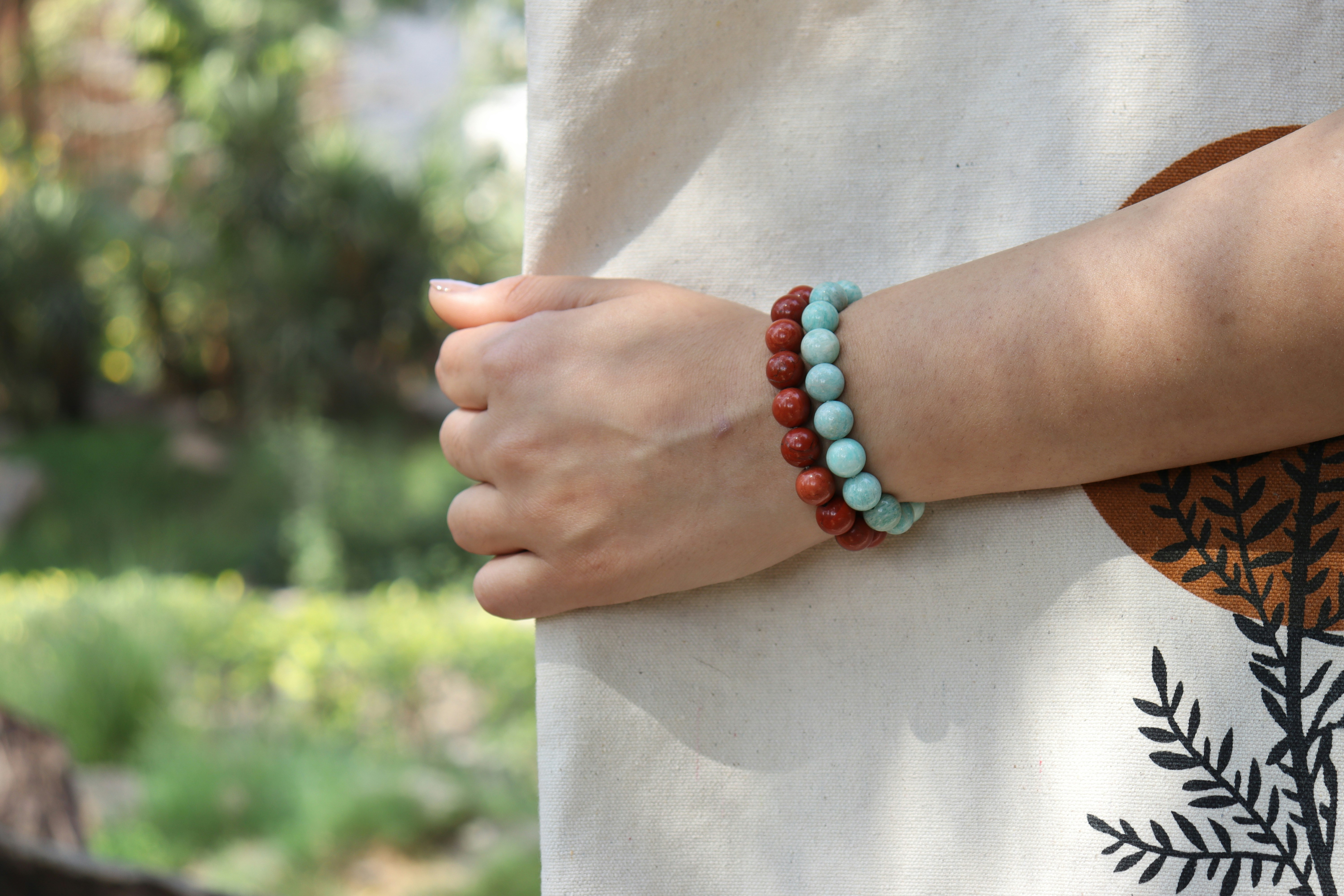 Woman's wrist adorned with two beaded bracelets.