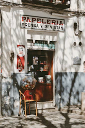 A vintage papeleria shop front with gum machine.