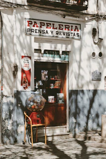 A vintage papeleria shop front with gum machine.