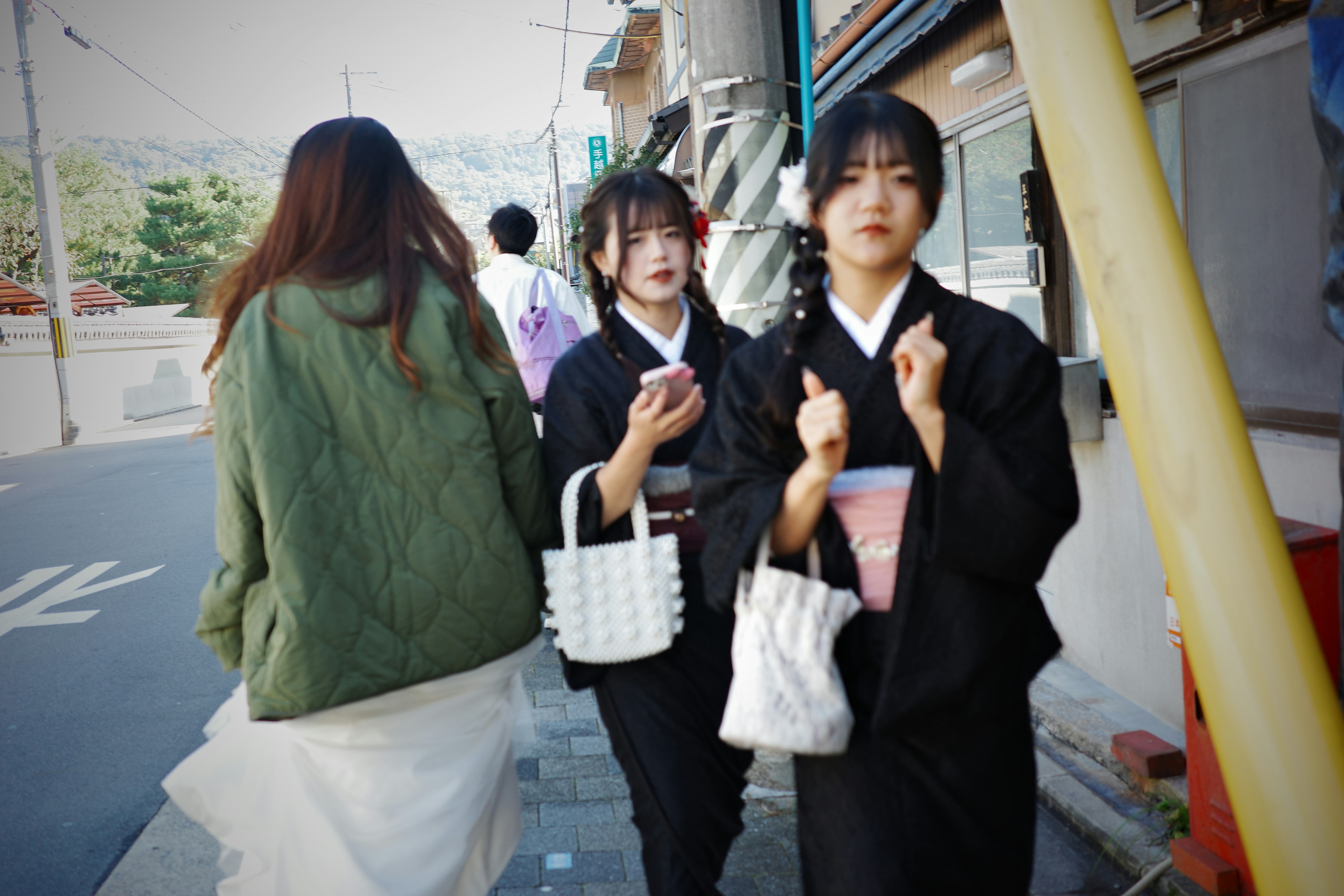 Two women in kimonos stroll down the street.