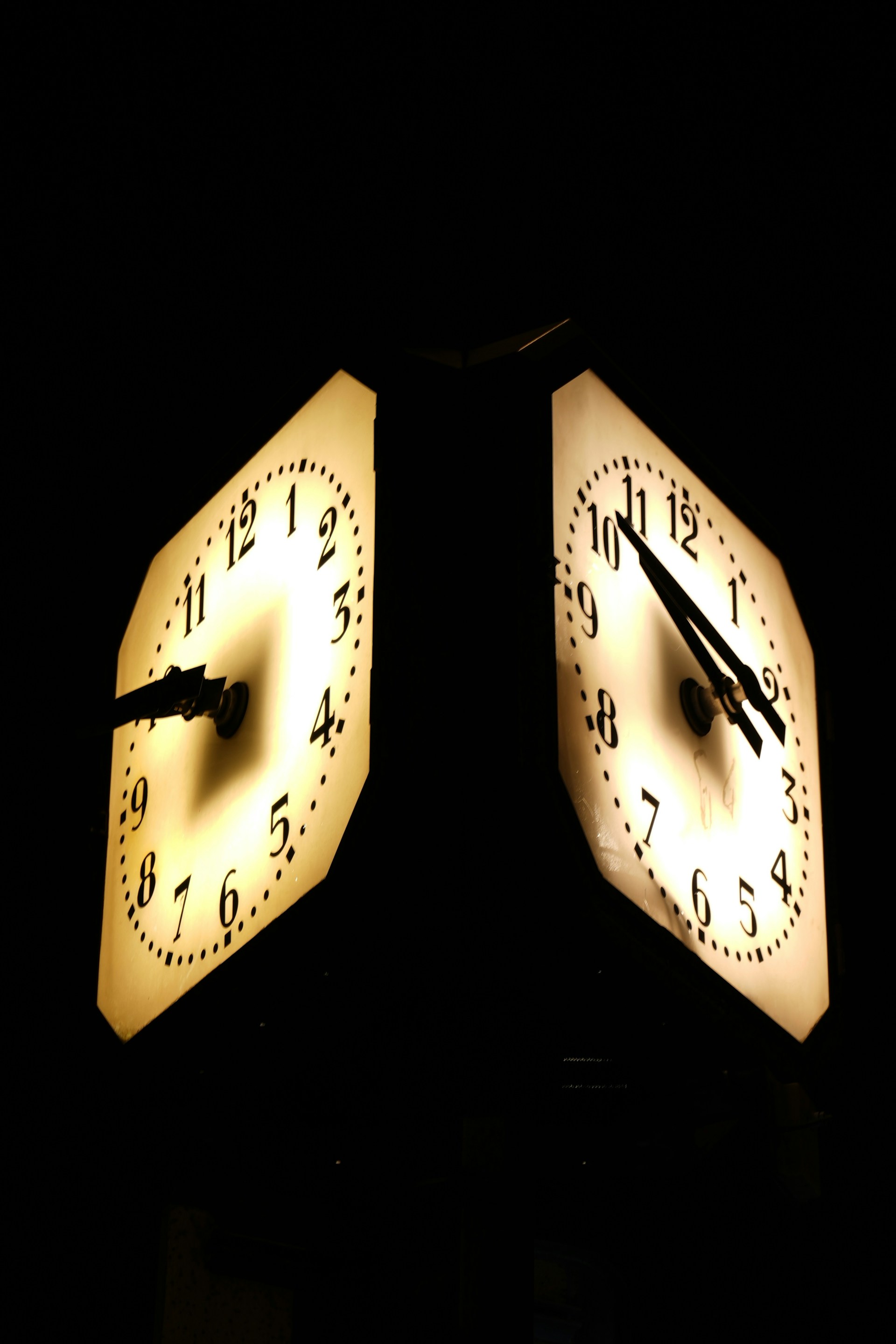 Two illuminated clocks show different times.