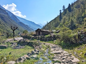Mountain landscape with a stone path and small house.