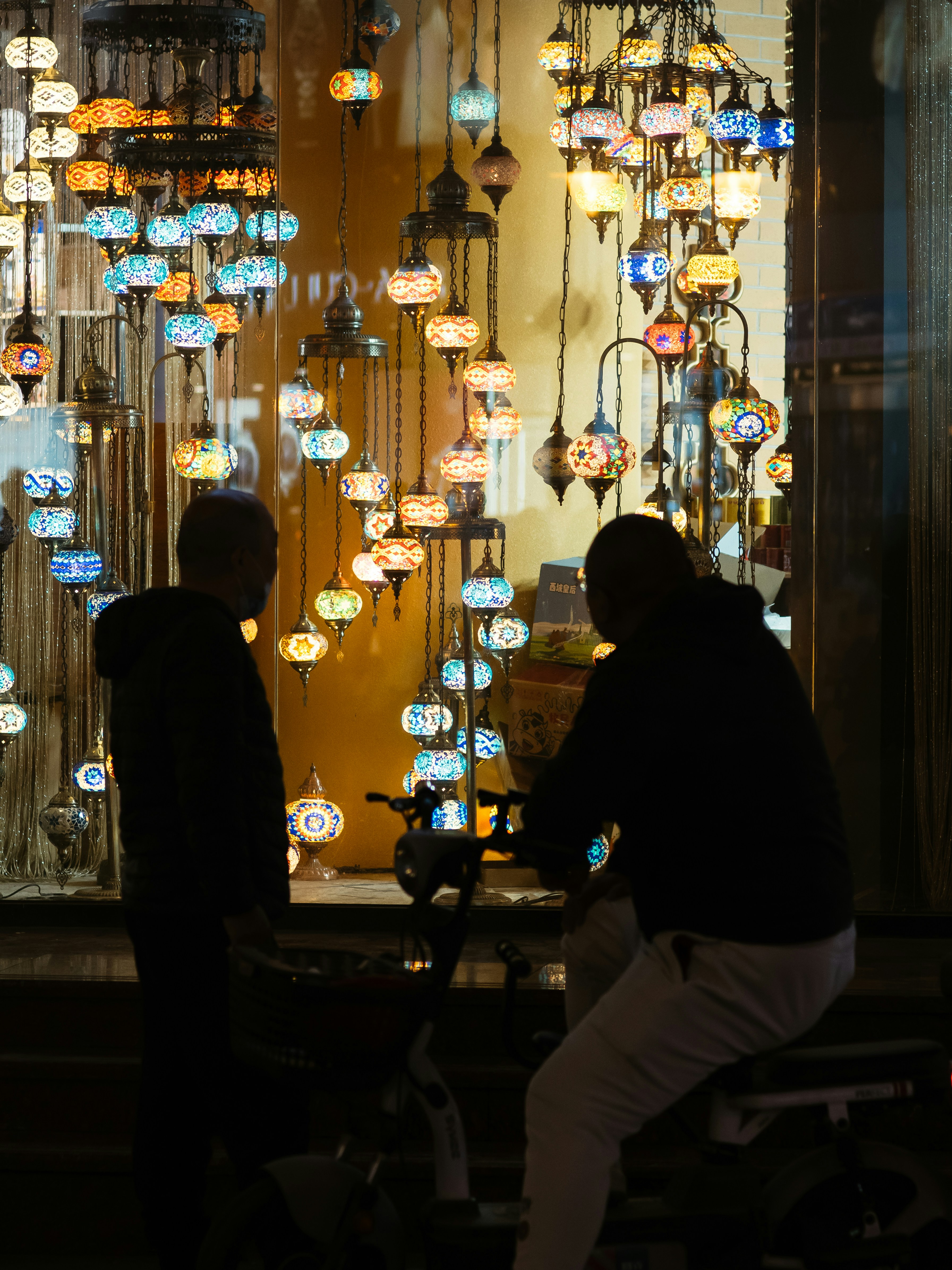 Os homens estão diante de lâmpadas decorativas bem iluminadas