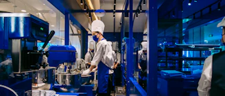 Chefs work in a modern, industrial-looking kitchen.