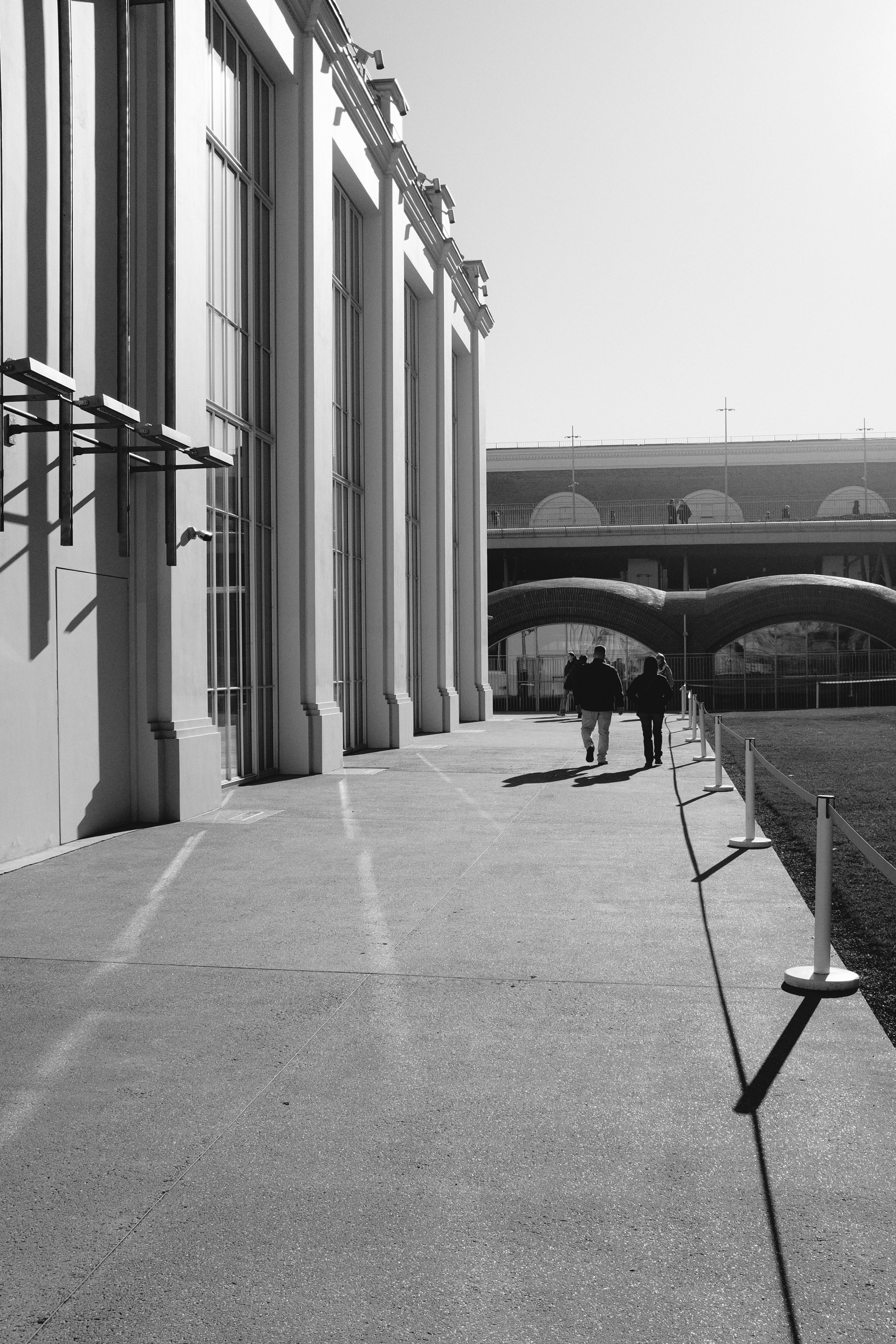 Las personas caminan por el pasillo exterior de un edificio.