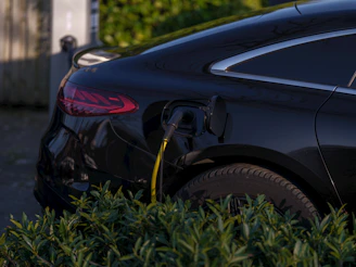 A black electric car is charging.