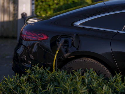 A black electric car is charging.