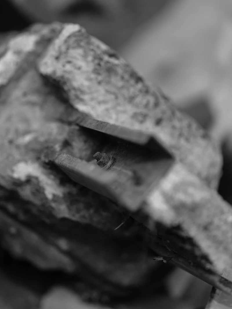 A close, textured detail of a mason's chisel against stone.