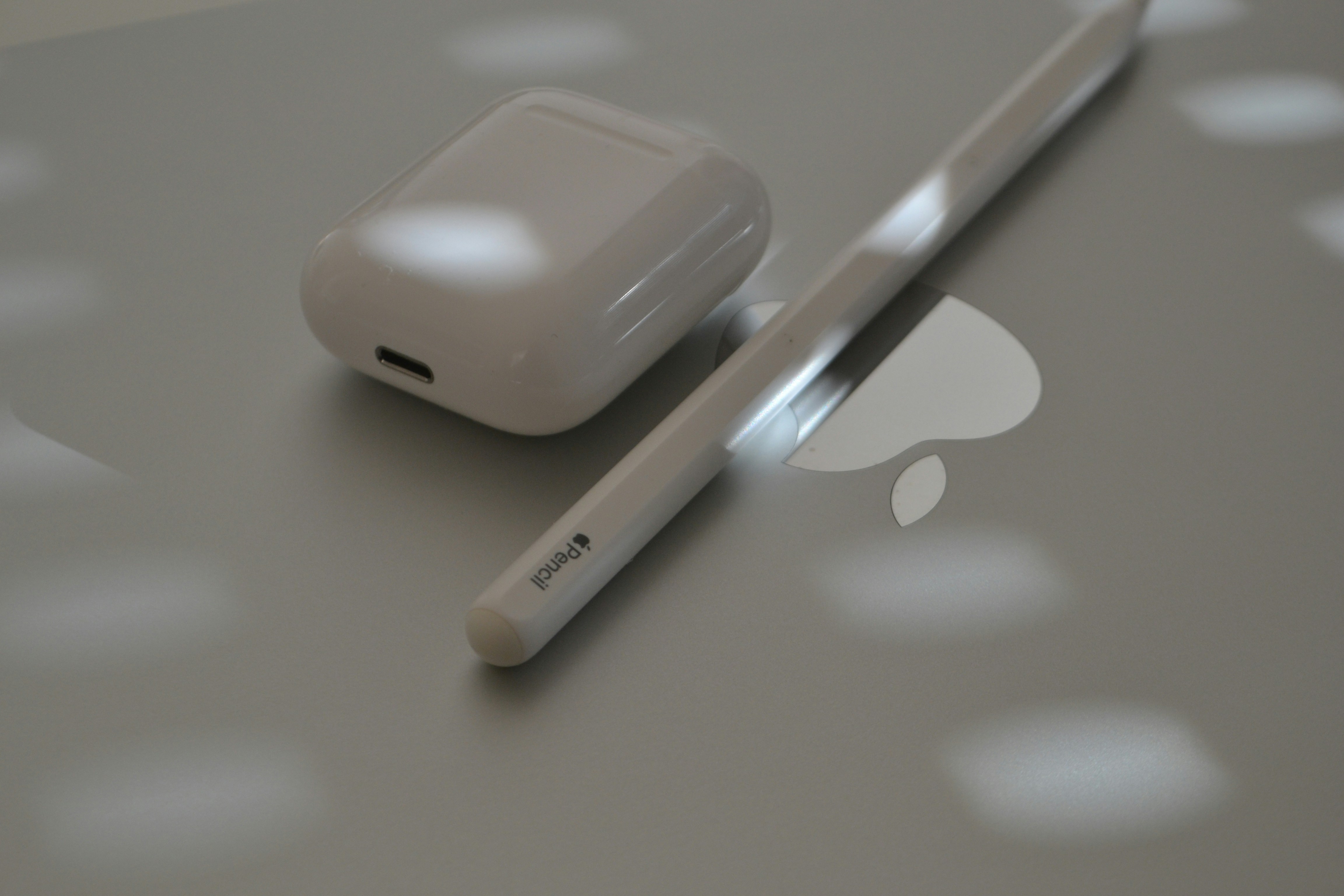 애플 펜슬과 에어팟이 맥북 위에 놓여 있습니다. 사진 – Unsplash의 무료 음악 이미지