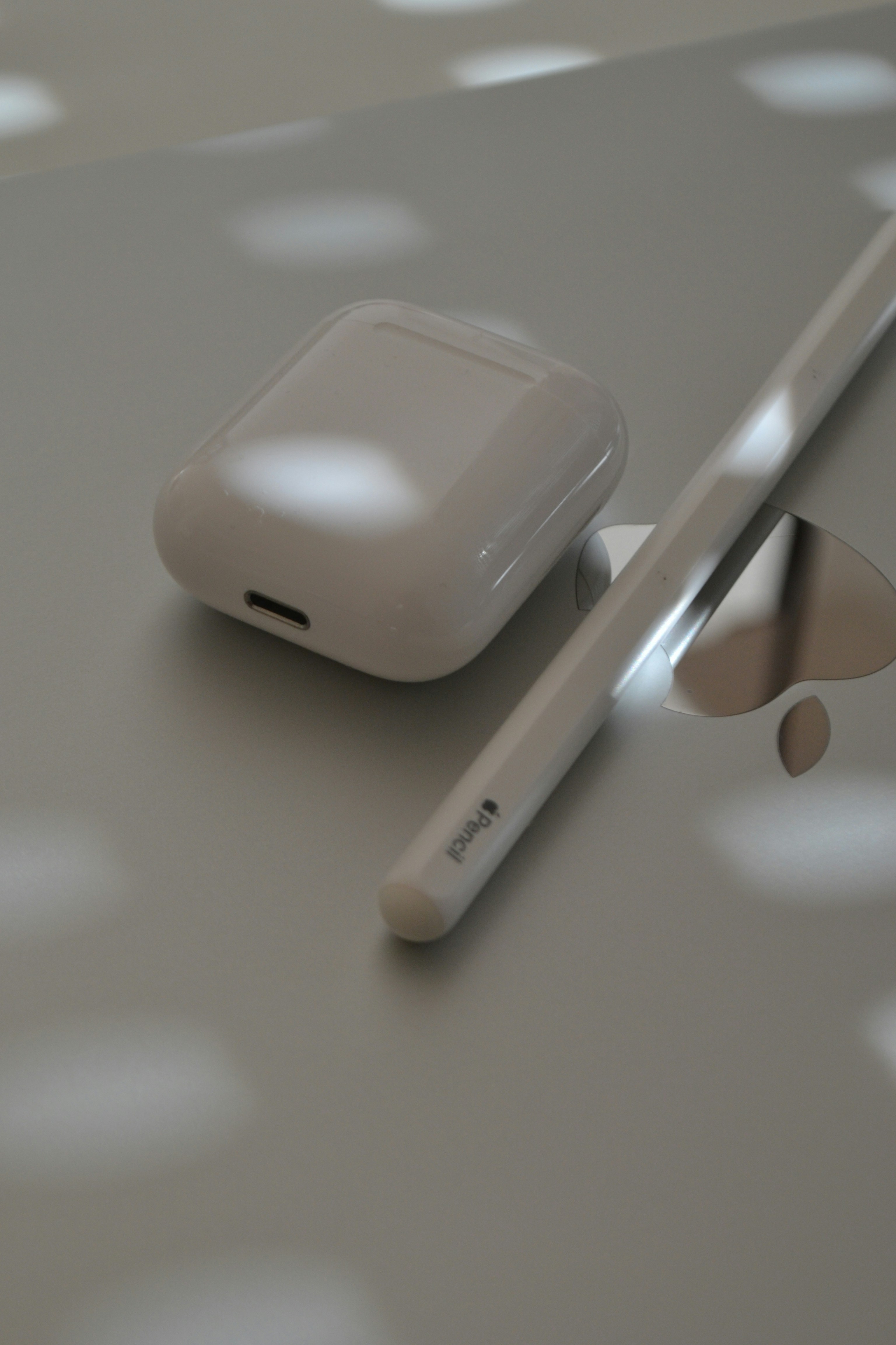 Airpods and apple pencil rest on a surface.