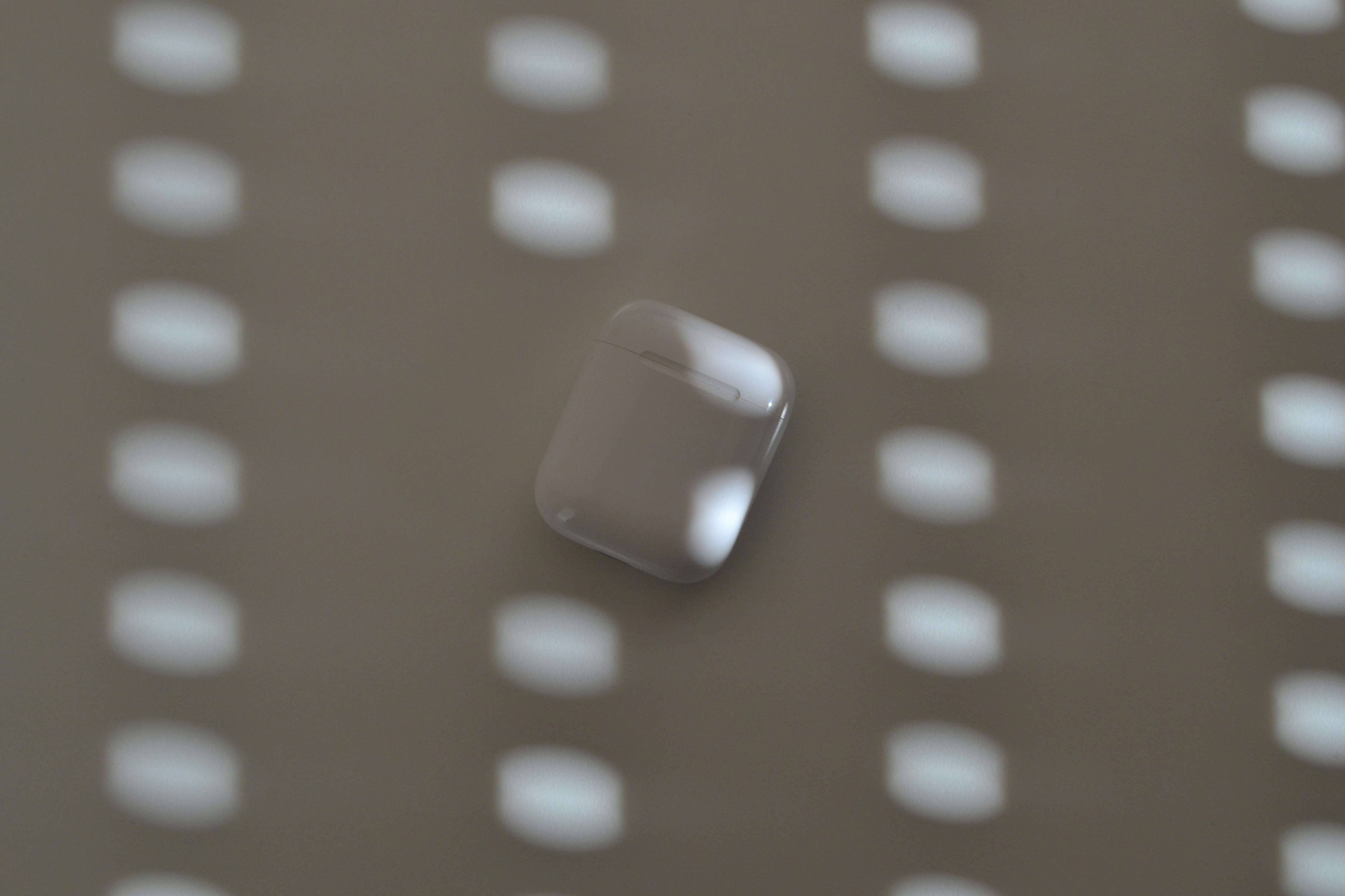 Airpods case against a patterned background.