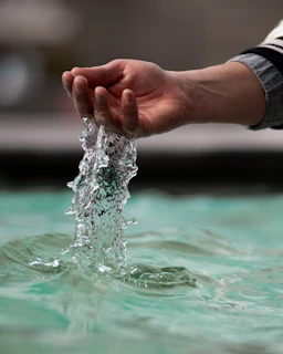 A hand plays with flowing water.